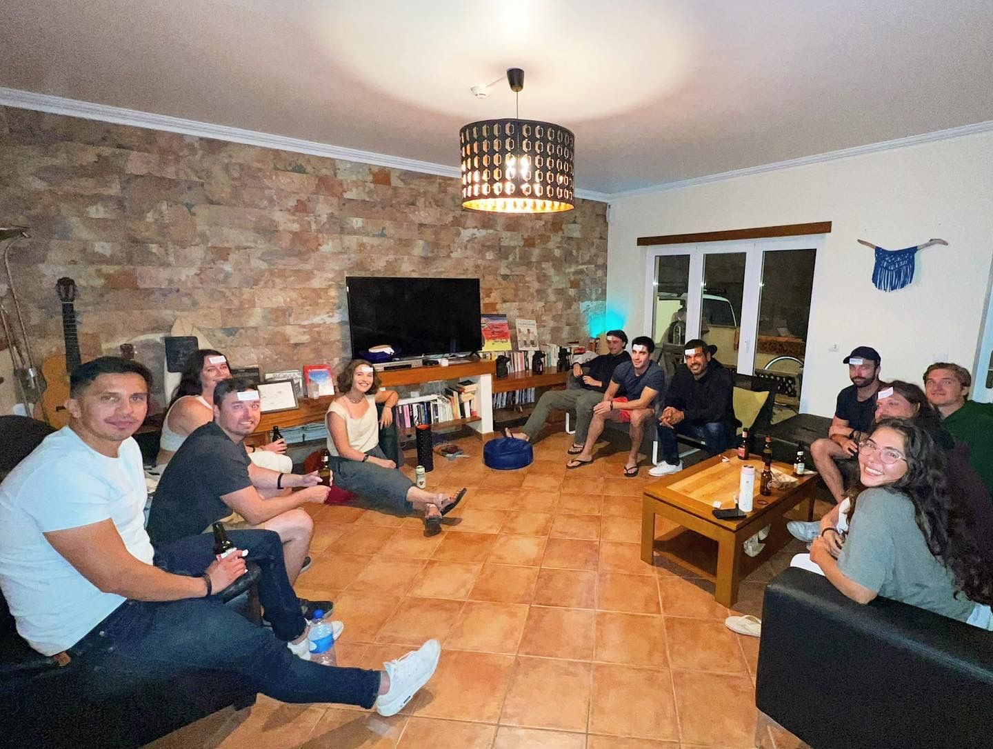 A group of people are sitting around a table in a living room.