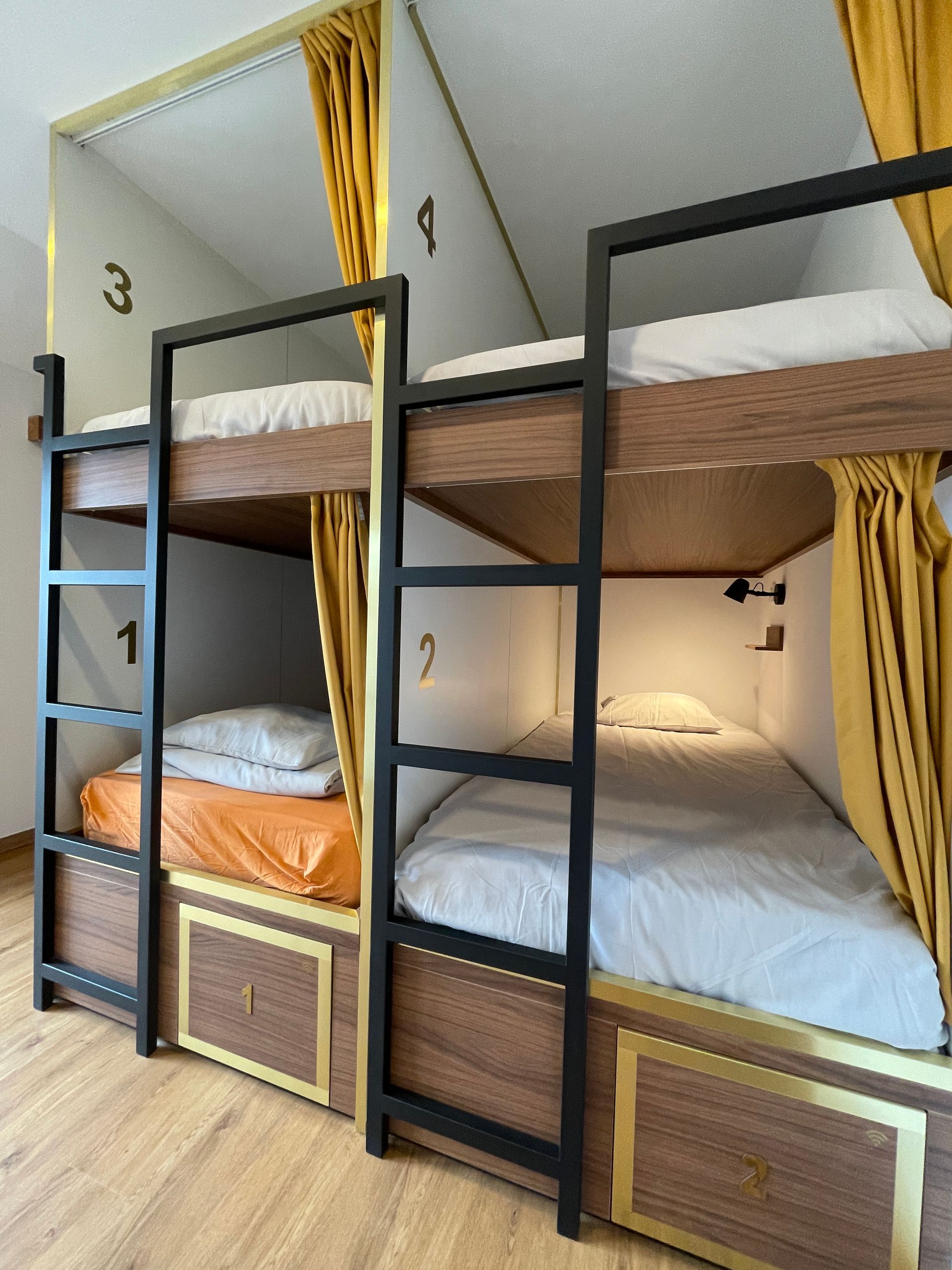 A row of bunk beds with numbers 1 2 and 3 on the wall