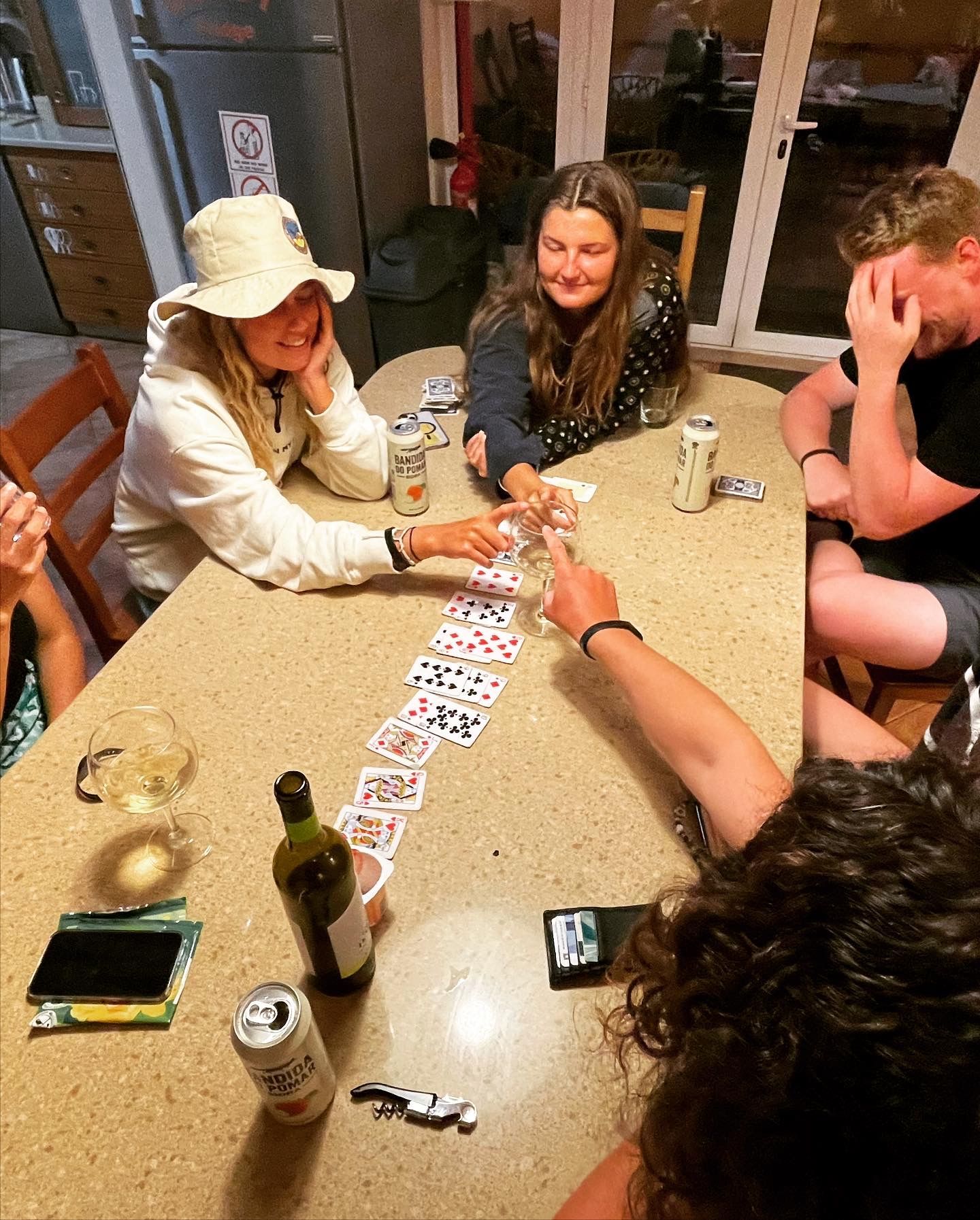 A group of people are sitting around a table playing cards.