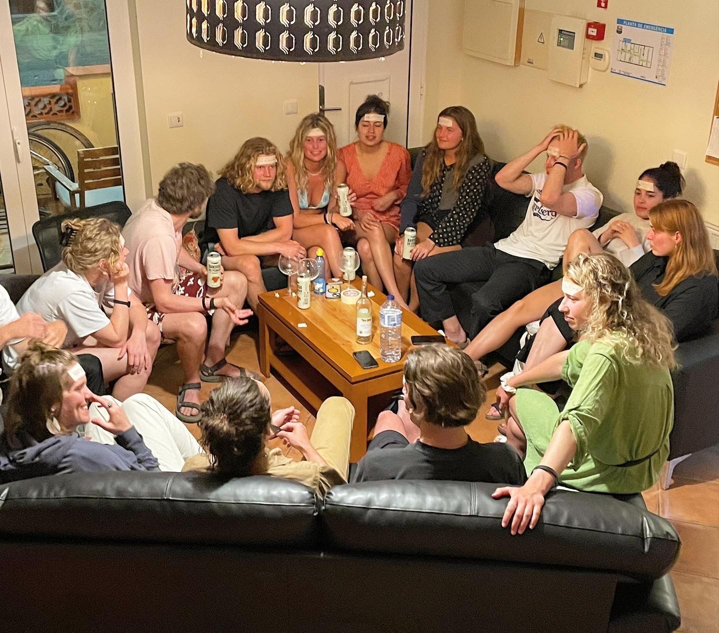 A group of people are sitting around a table in a living room