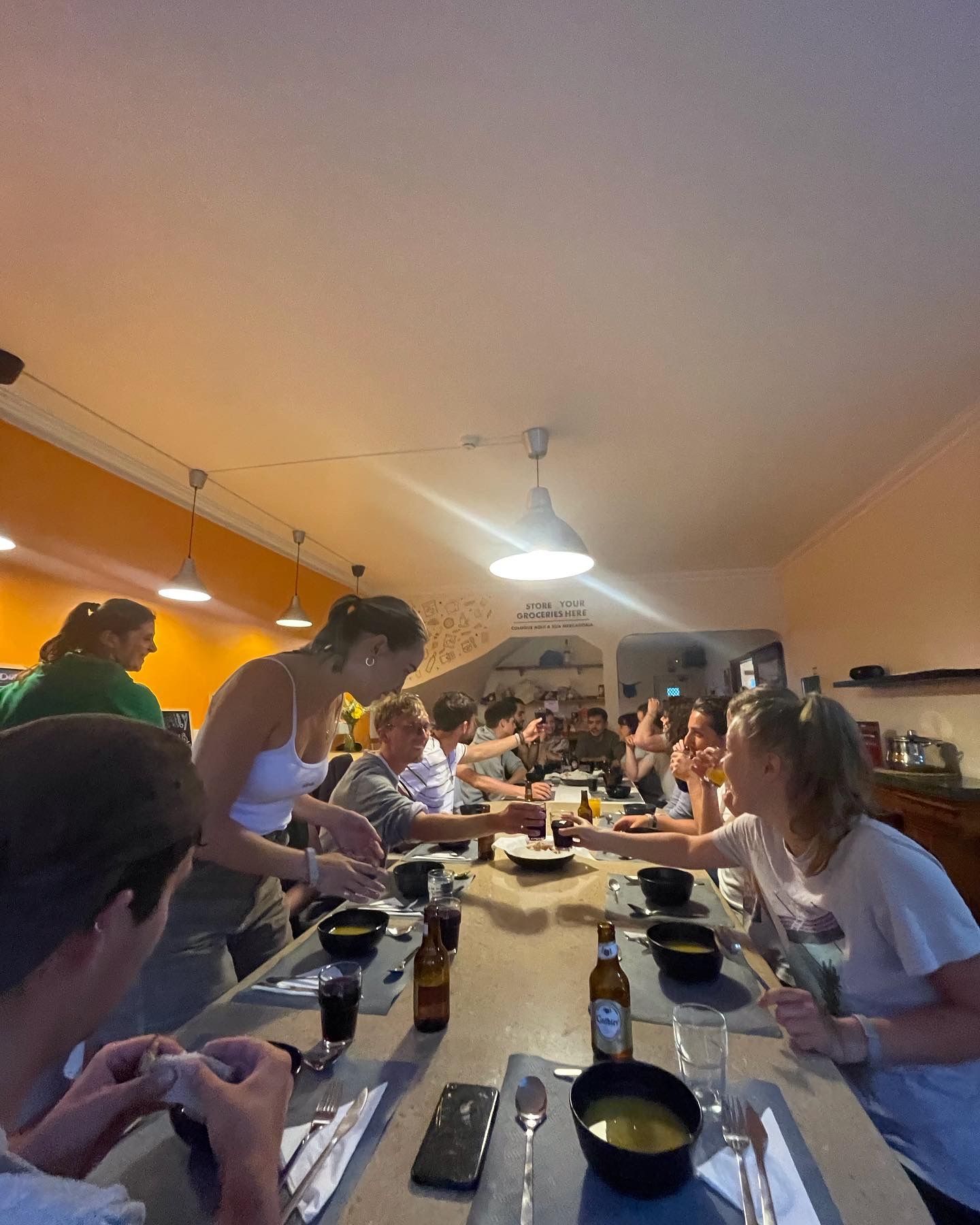 A group of people are sitting at a long table eating food.