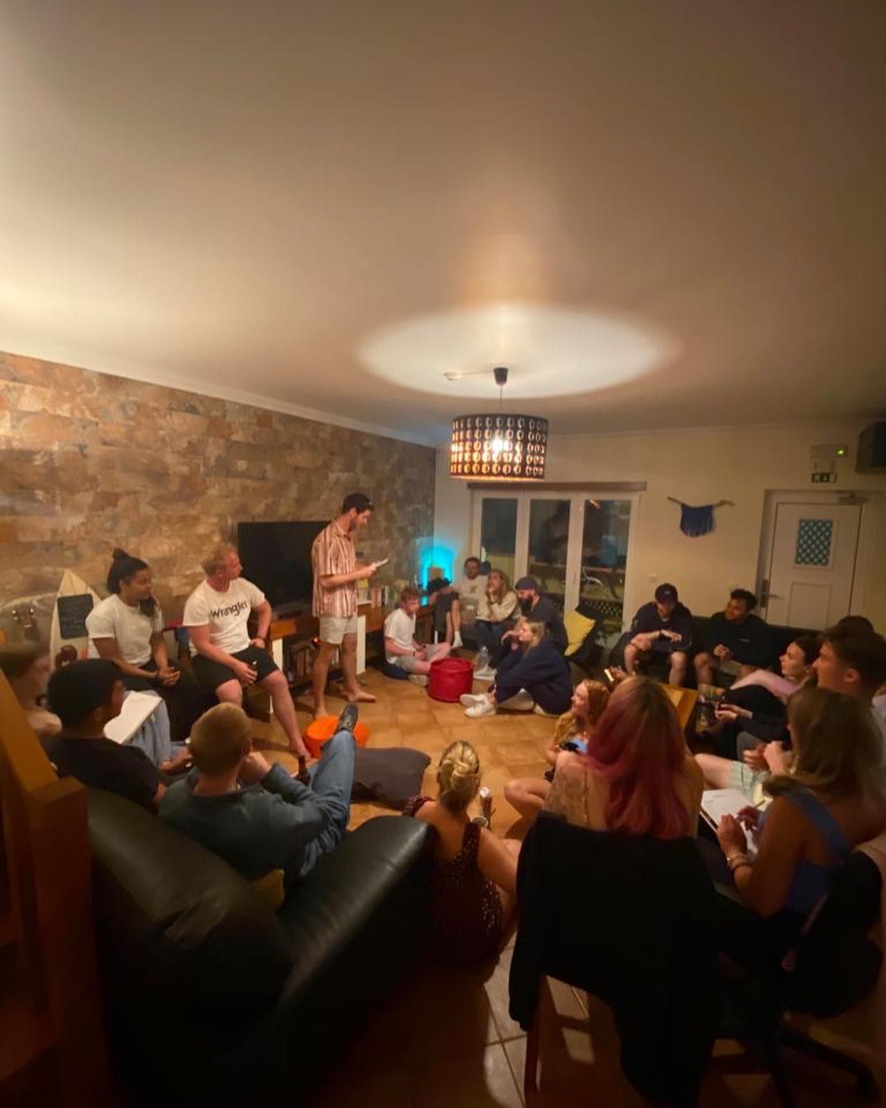 A group of people are sitting around a table in a living room.