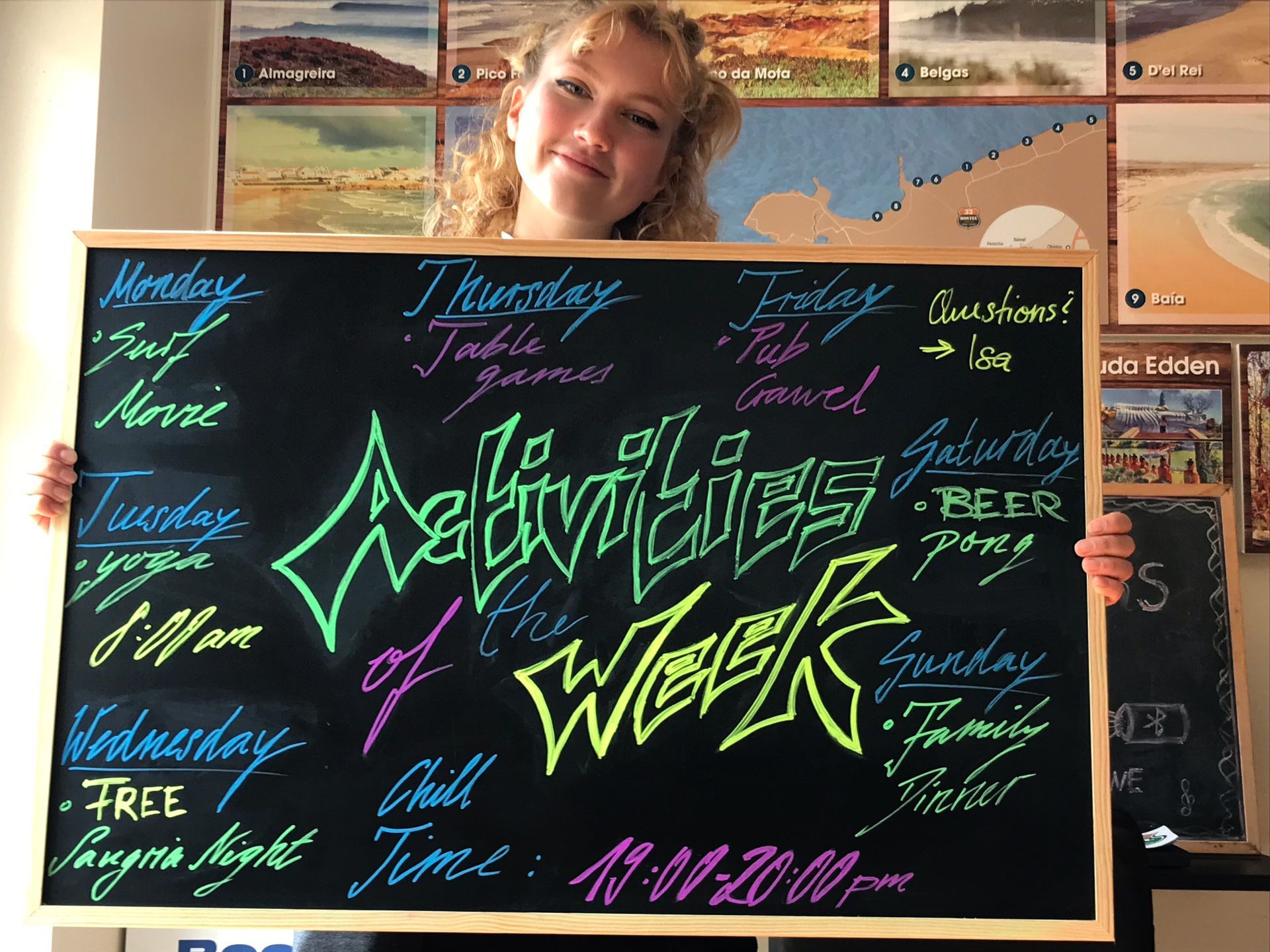 A woman is holding a blackboard that says activities of the week