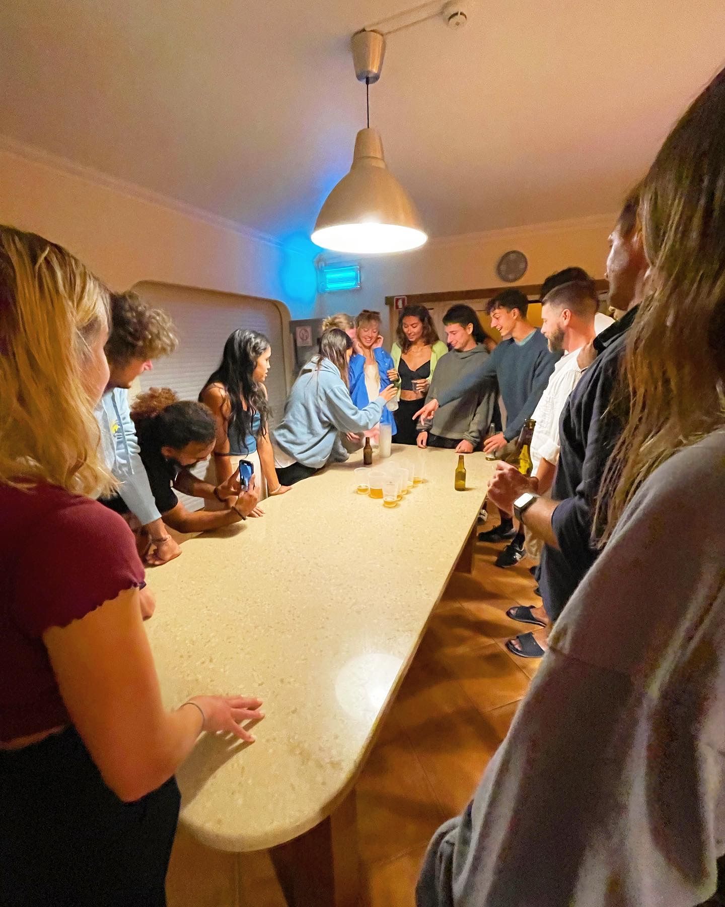 A group of people are standing around a long table.