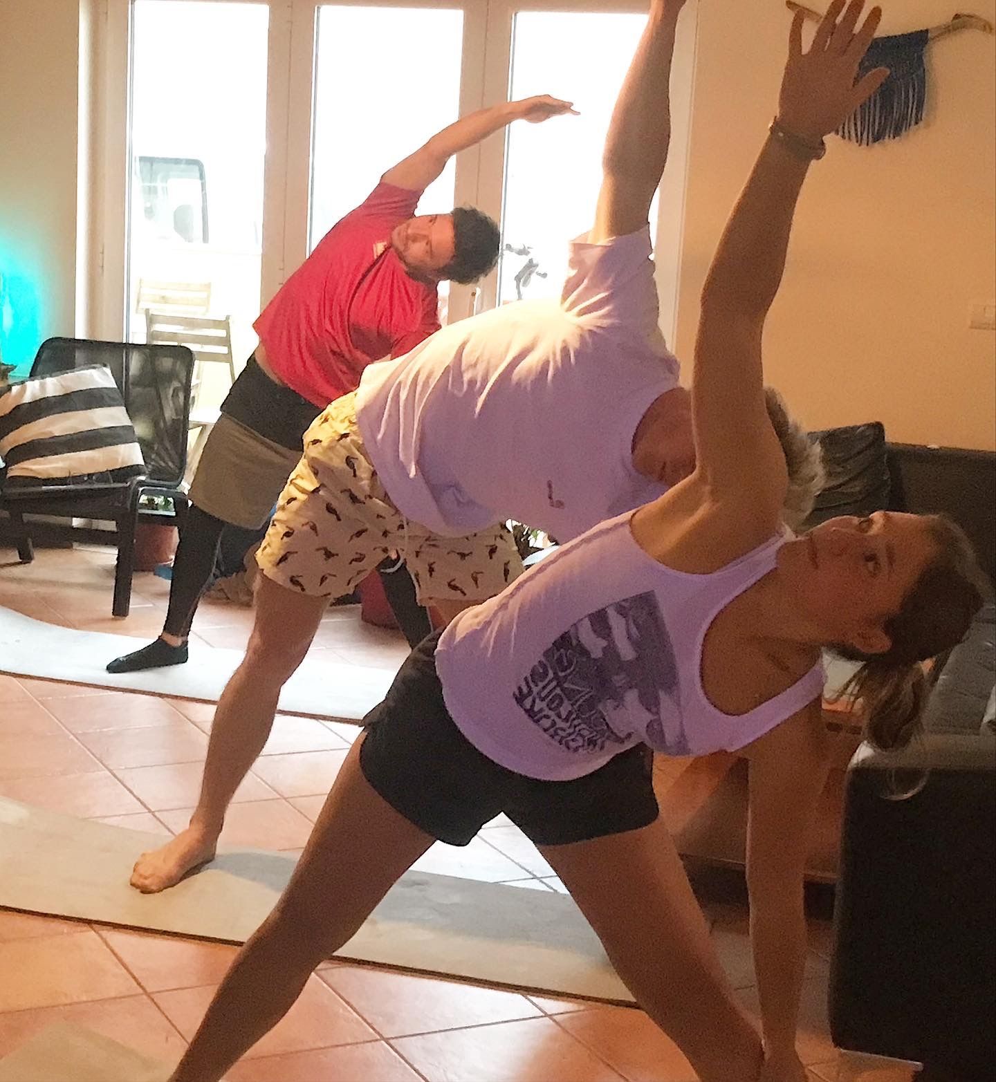A group of people are doing yoga in a living room