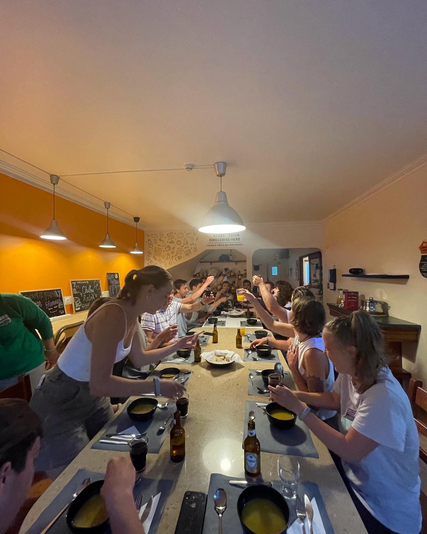 A group of people are sitting at a long table eating food.