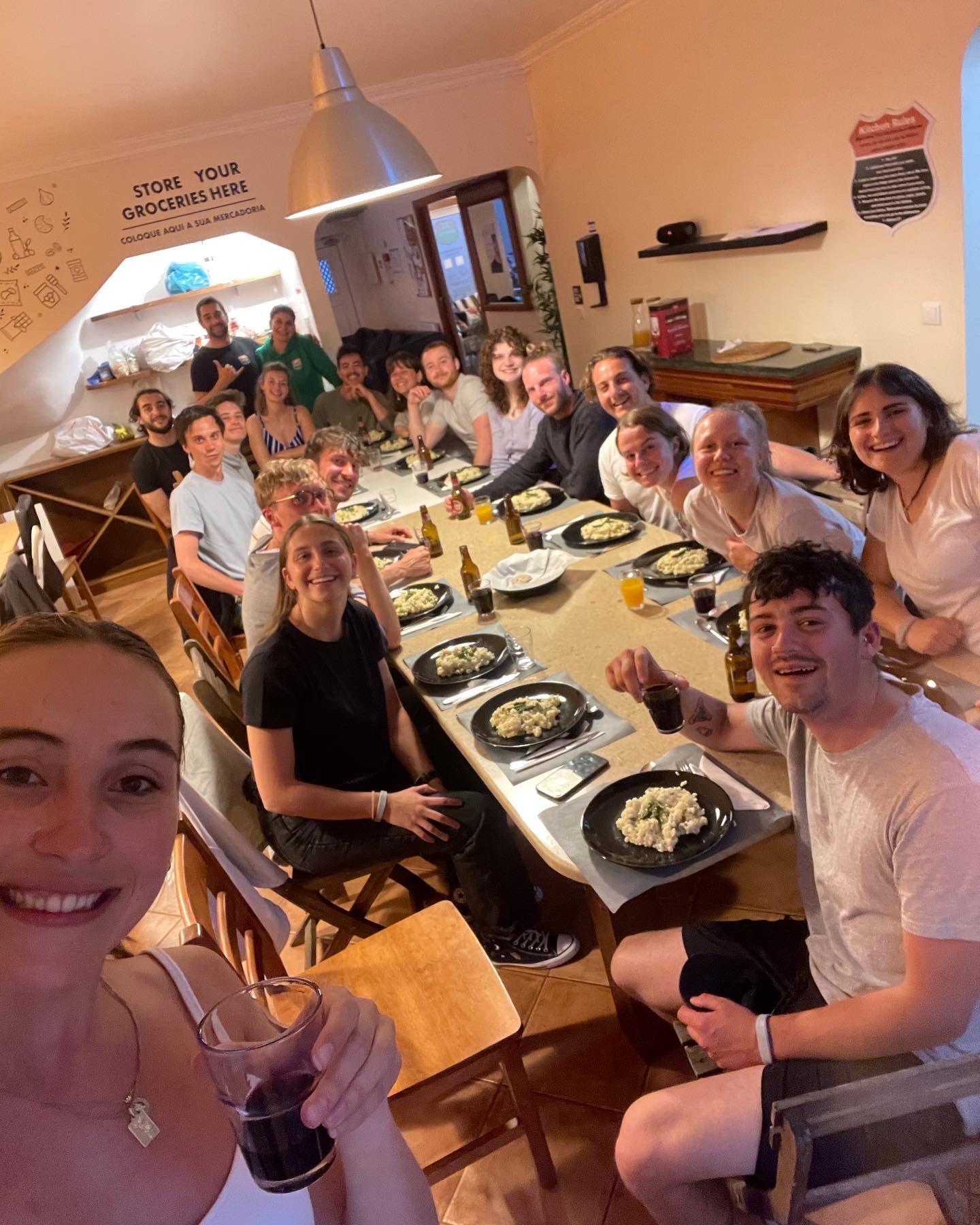 A group of people are sitting around a long table eating food.