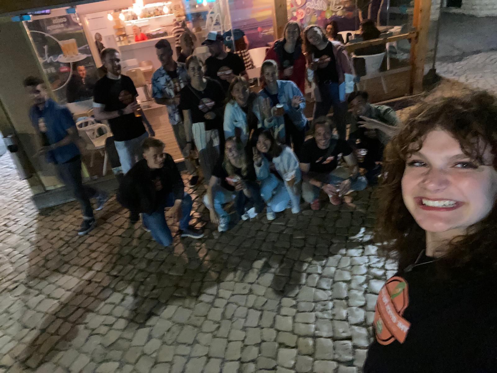 A group of people are posing for a picture on a cobblestone street.