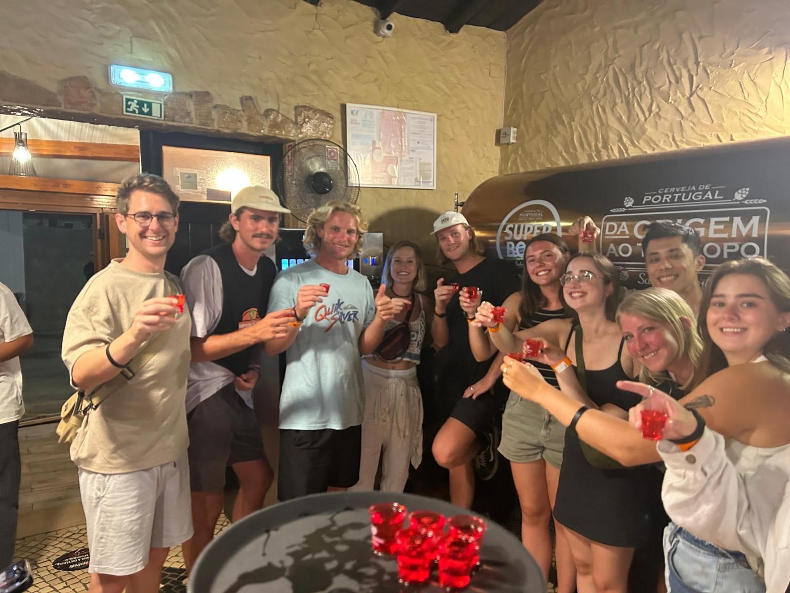A group of people are standing around a table holding glasses of wine.