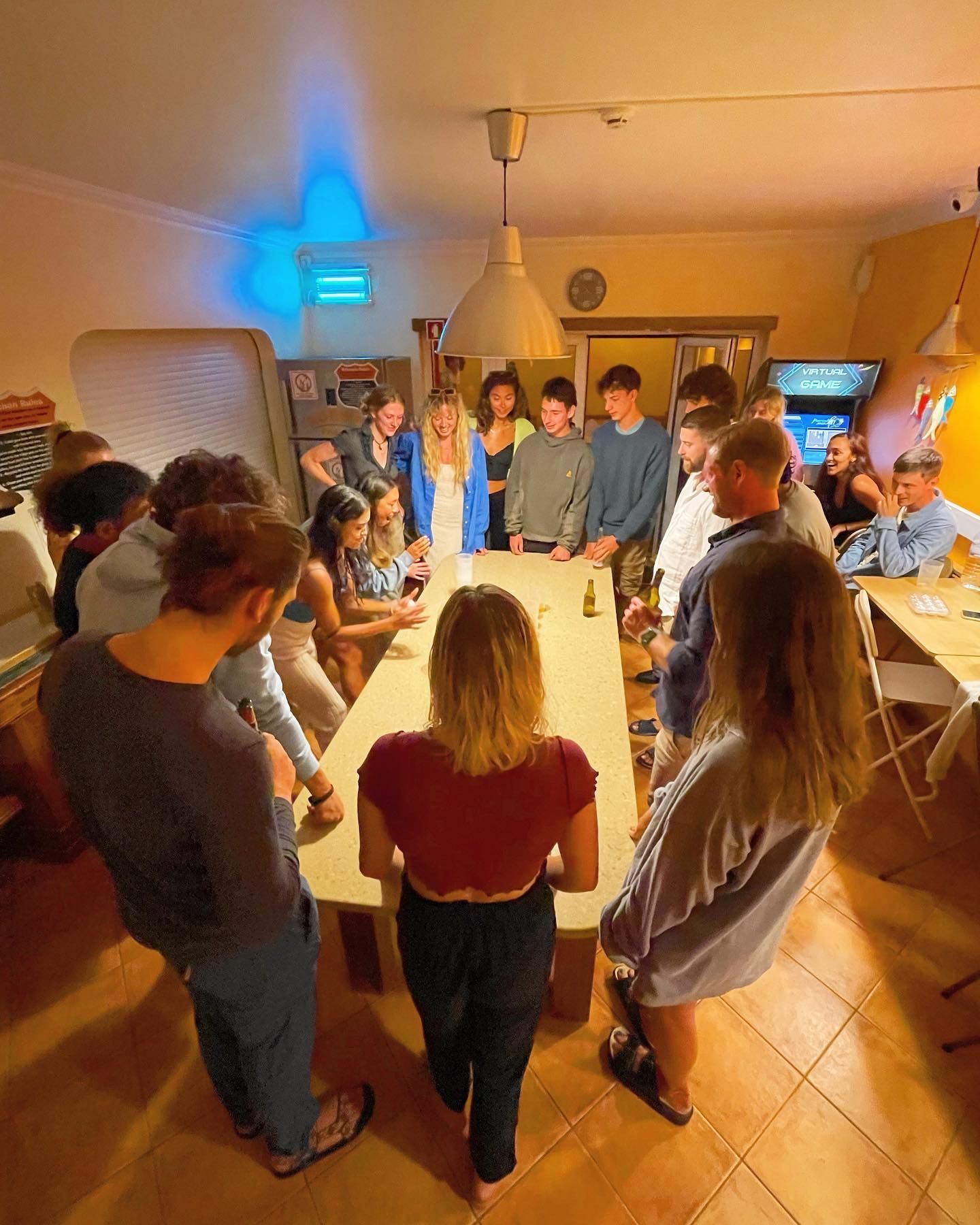 A group of people are standing around a table in a room.