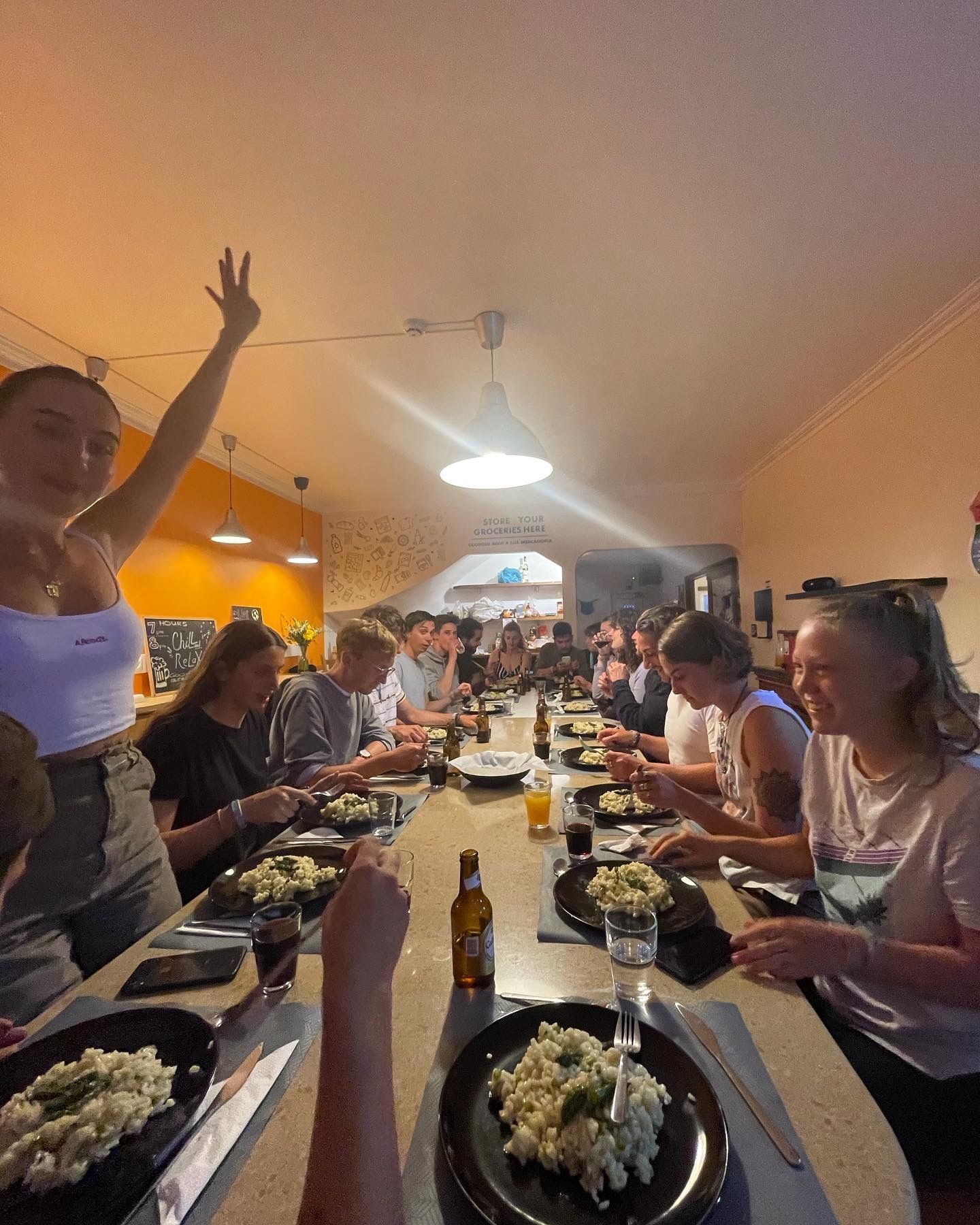 A group of people are sitting at a long table eating food.