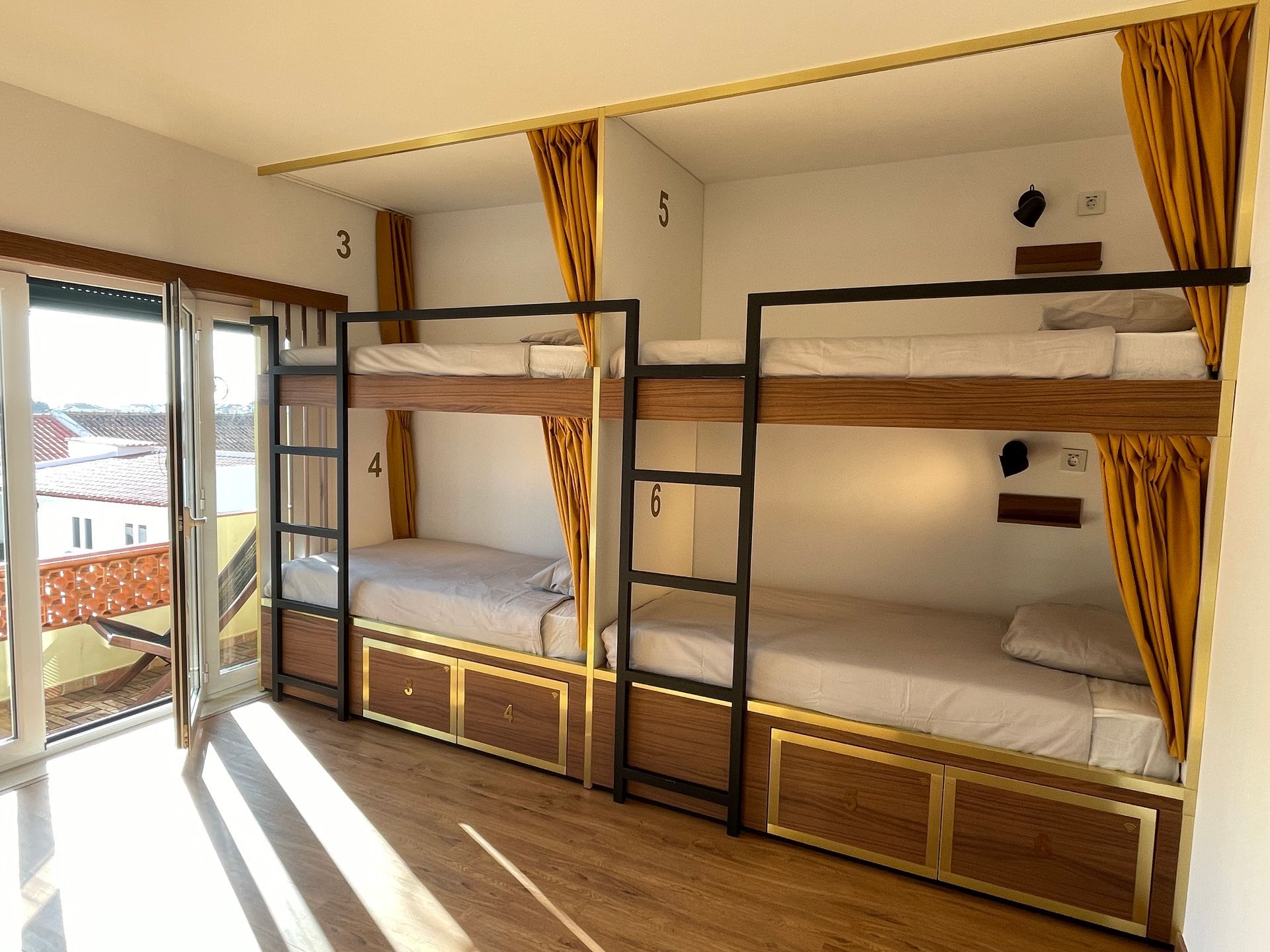 A room with four bunk beds and a sliding glass door