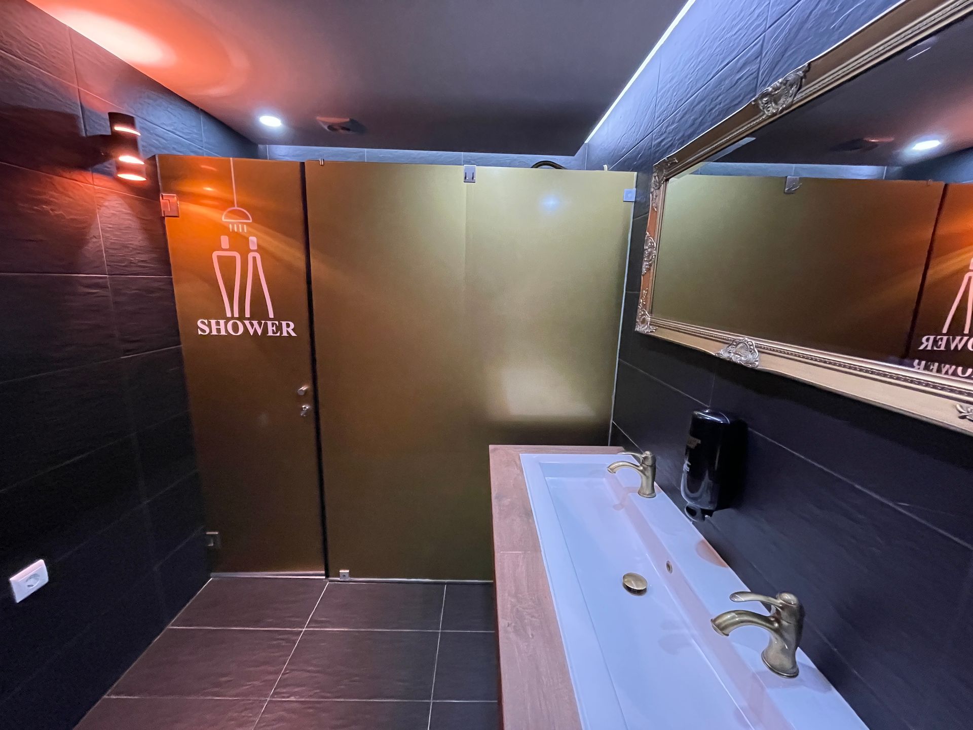 A bathroom with two sinks , a mirror and a shower stall.