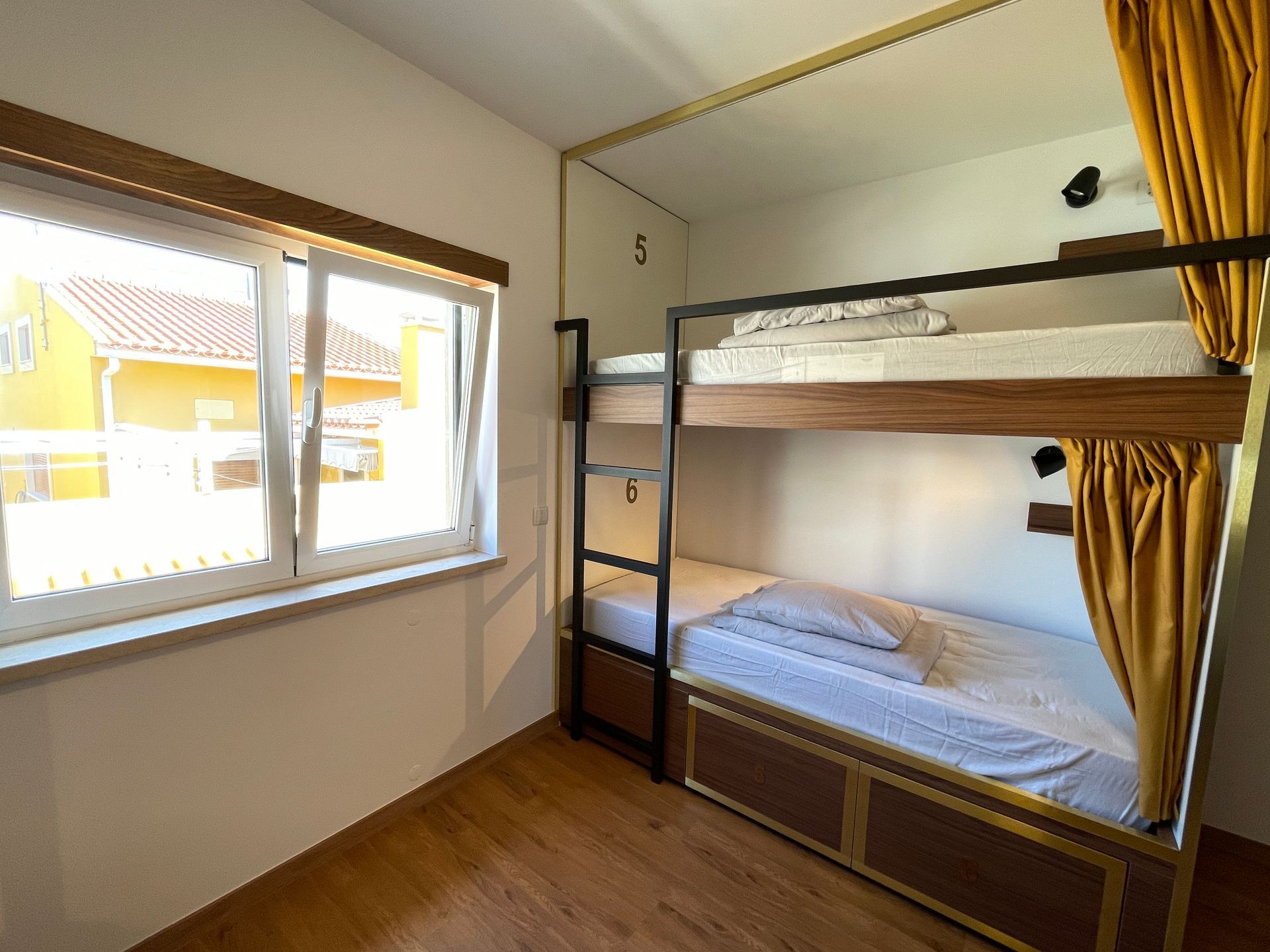 A bedroom with two bunk beds and a window.