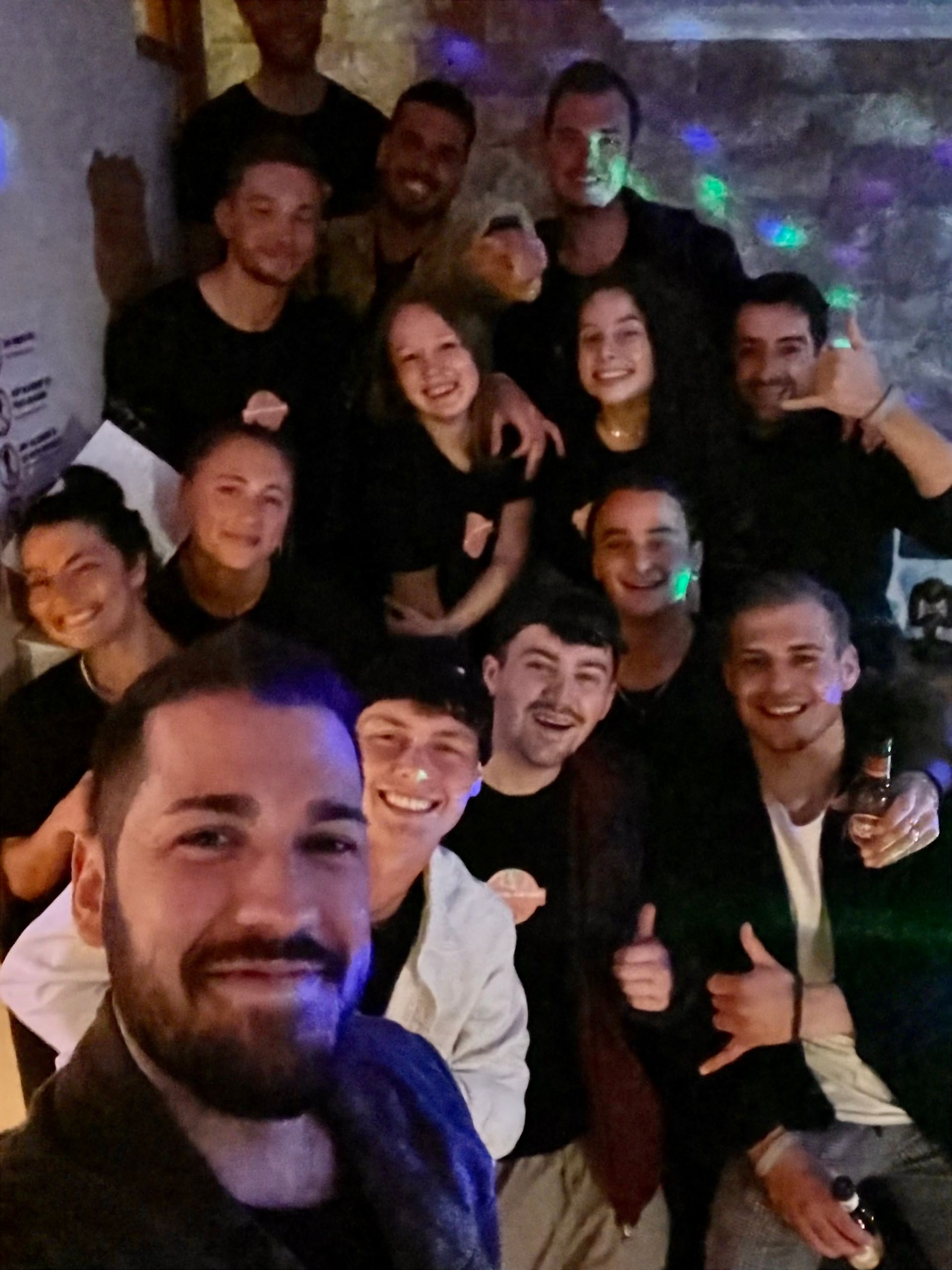 A group of people posing for a picture with one man giving a thumbs up