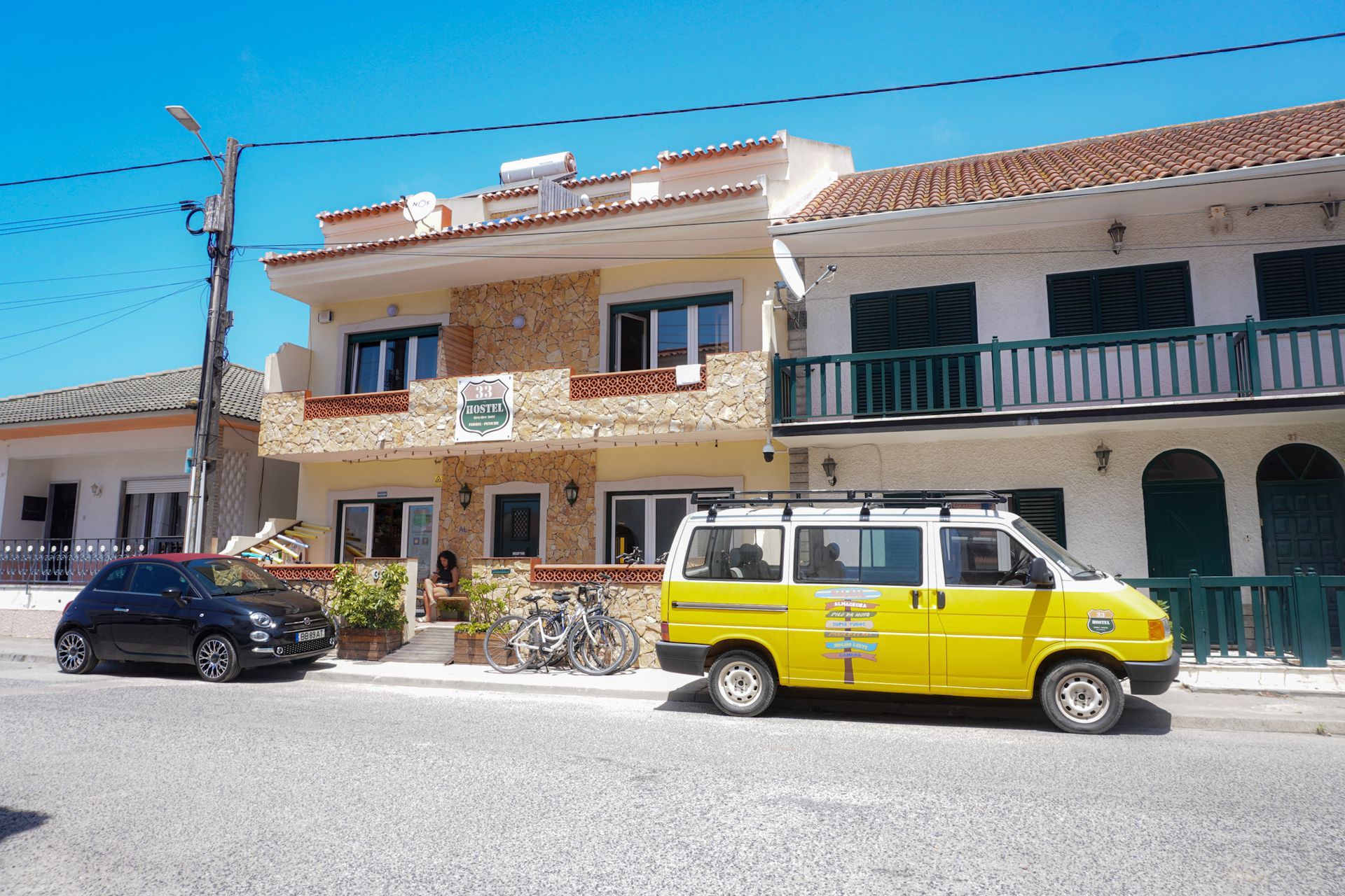 A yellow van is parked in front of a building