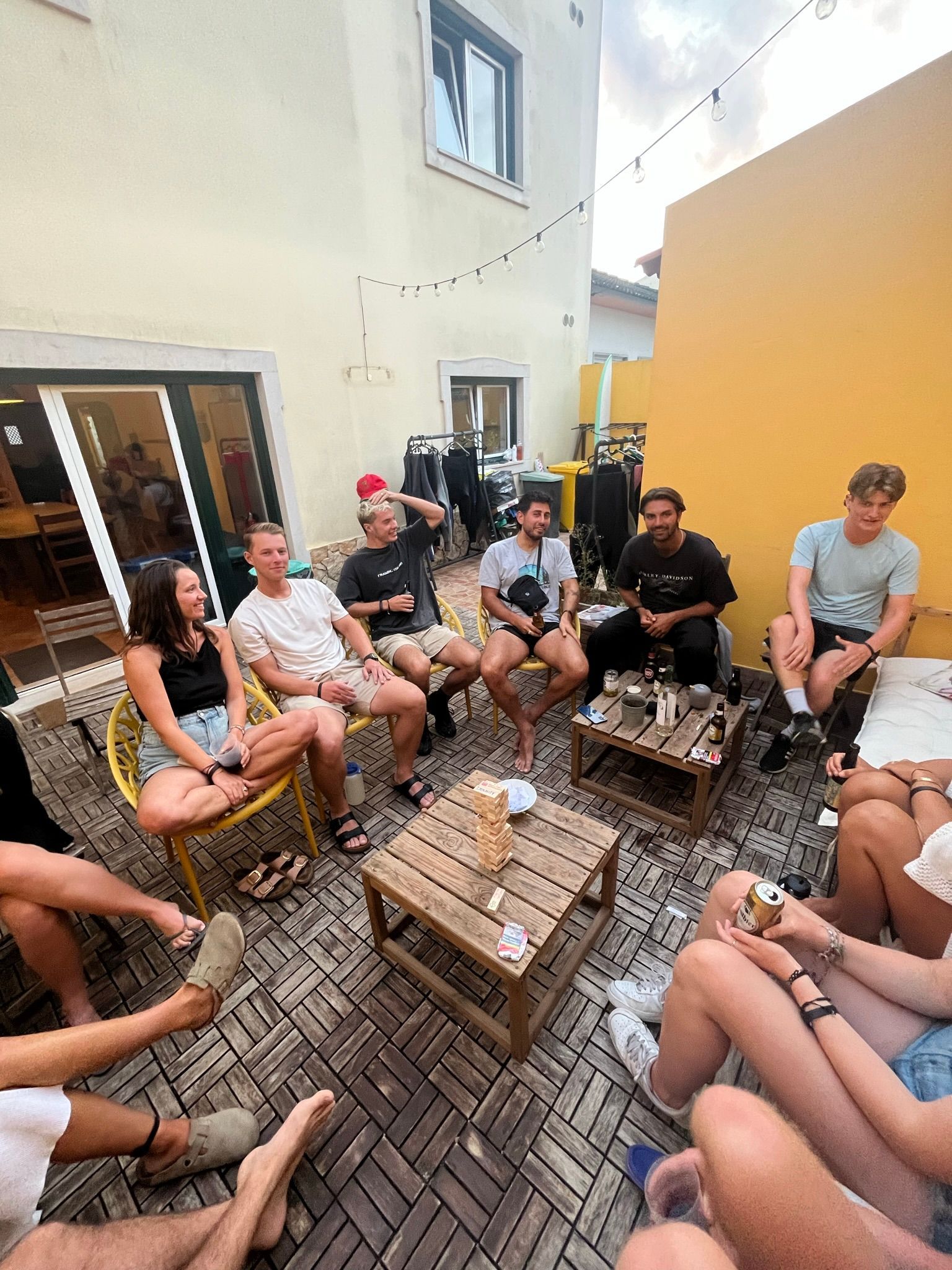 A group of people are sitting in a circle on a patio.