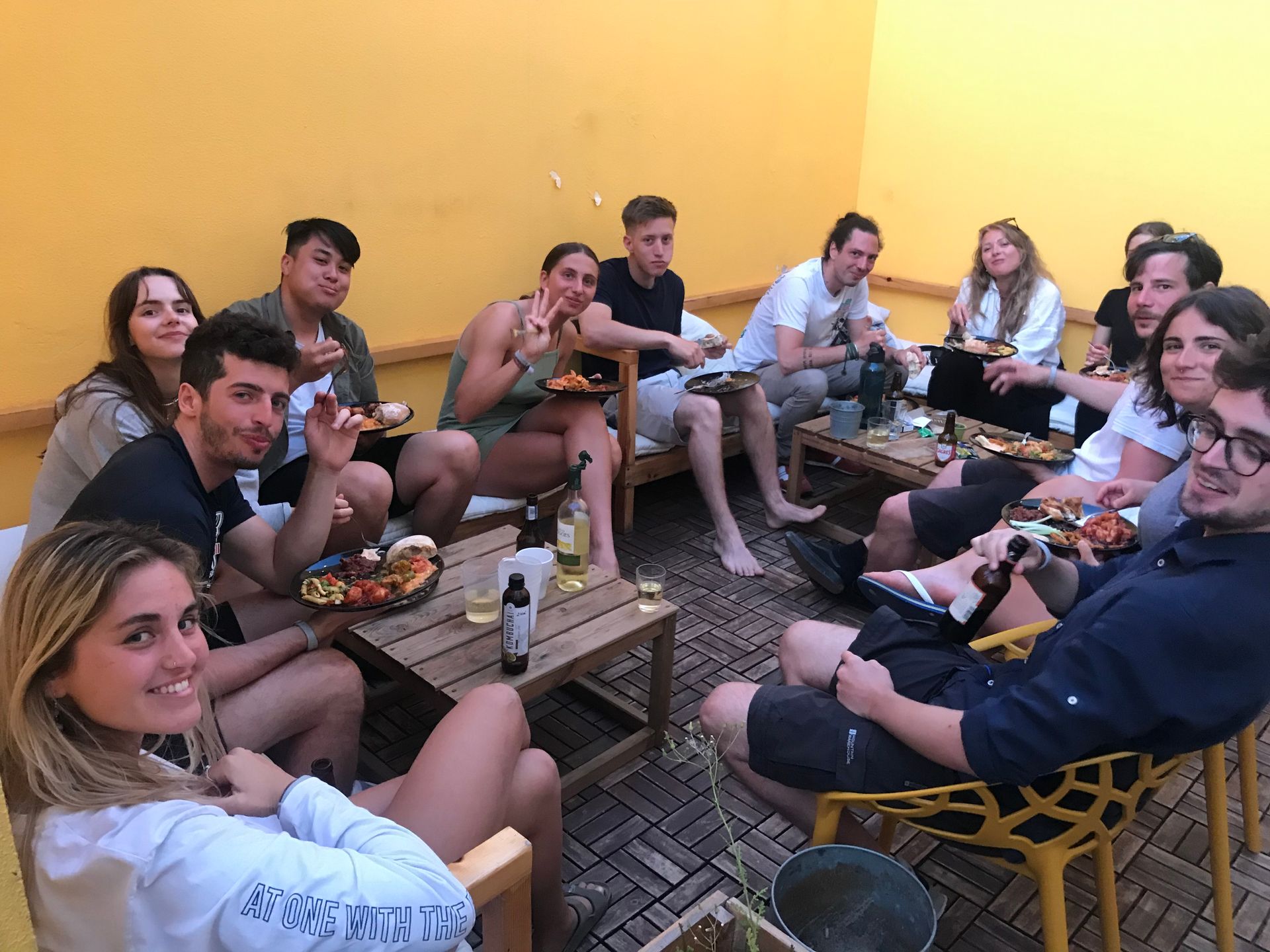 A group of people are sitting around a table eating pizza and drinking beer.