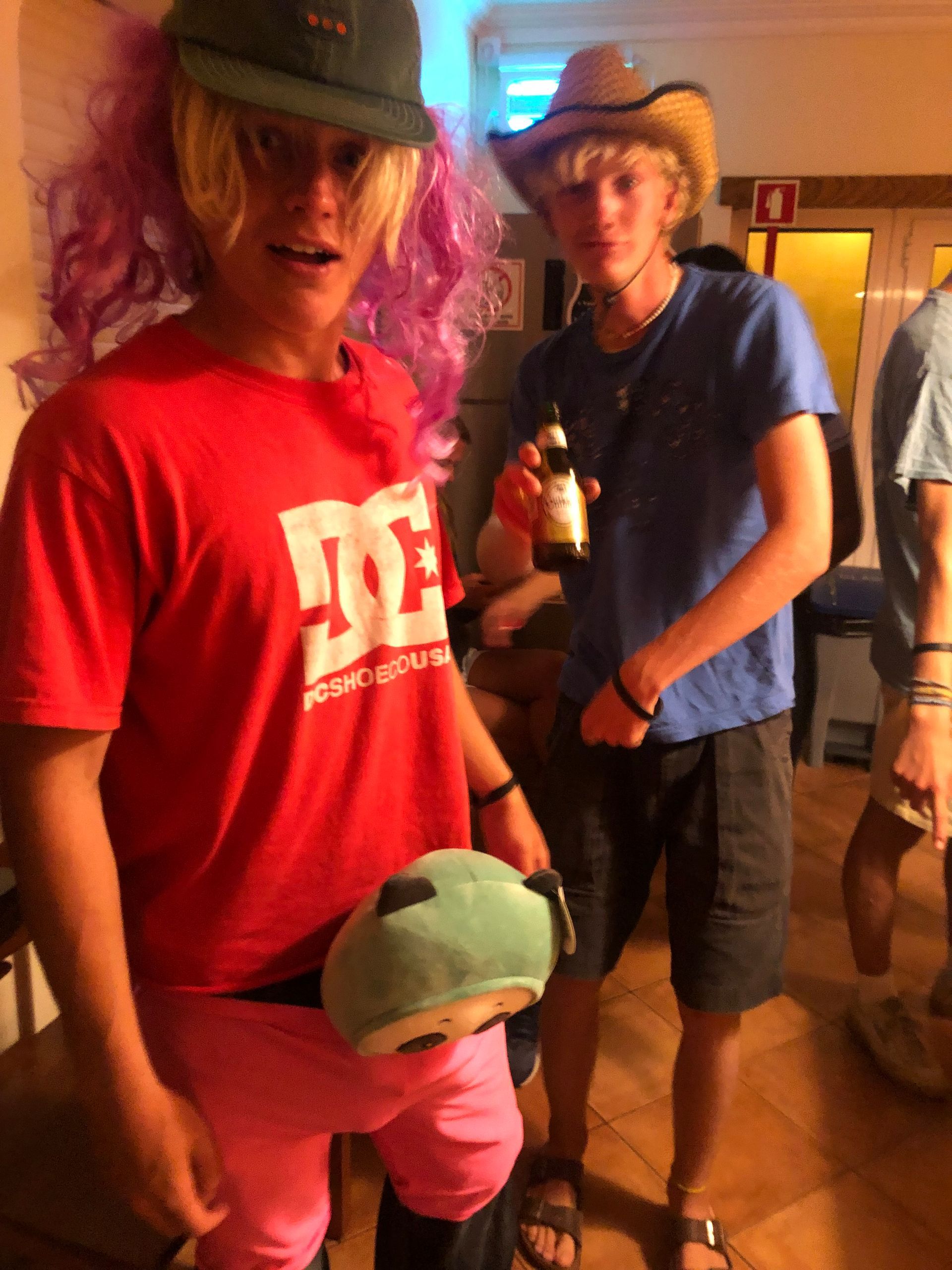 A man wearing a red shirt that says dc on it