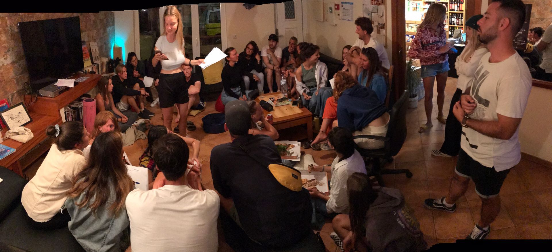 A group of people are sitting in a circle in a living room.