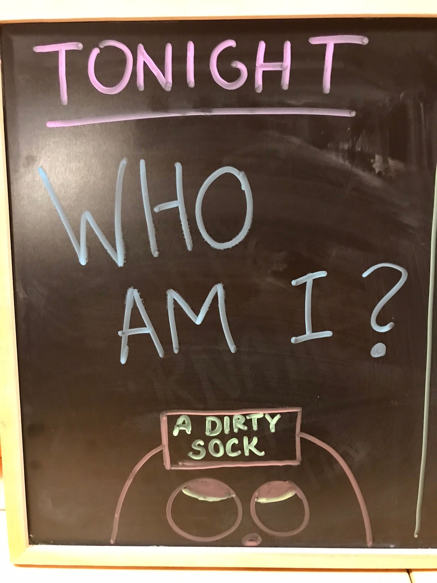 A chalkboard with the words tonight who am i written on it