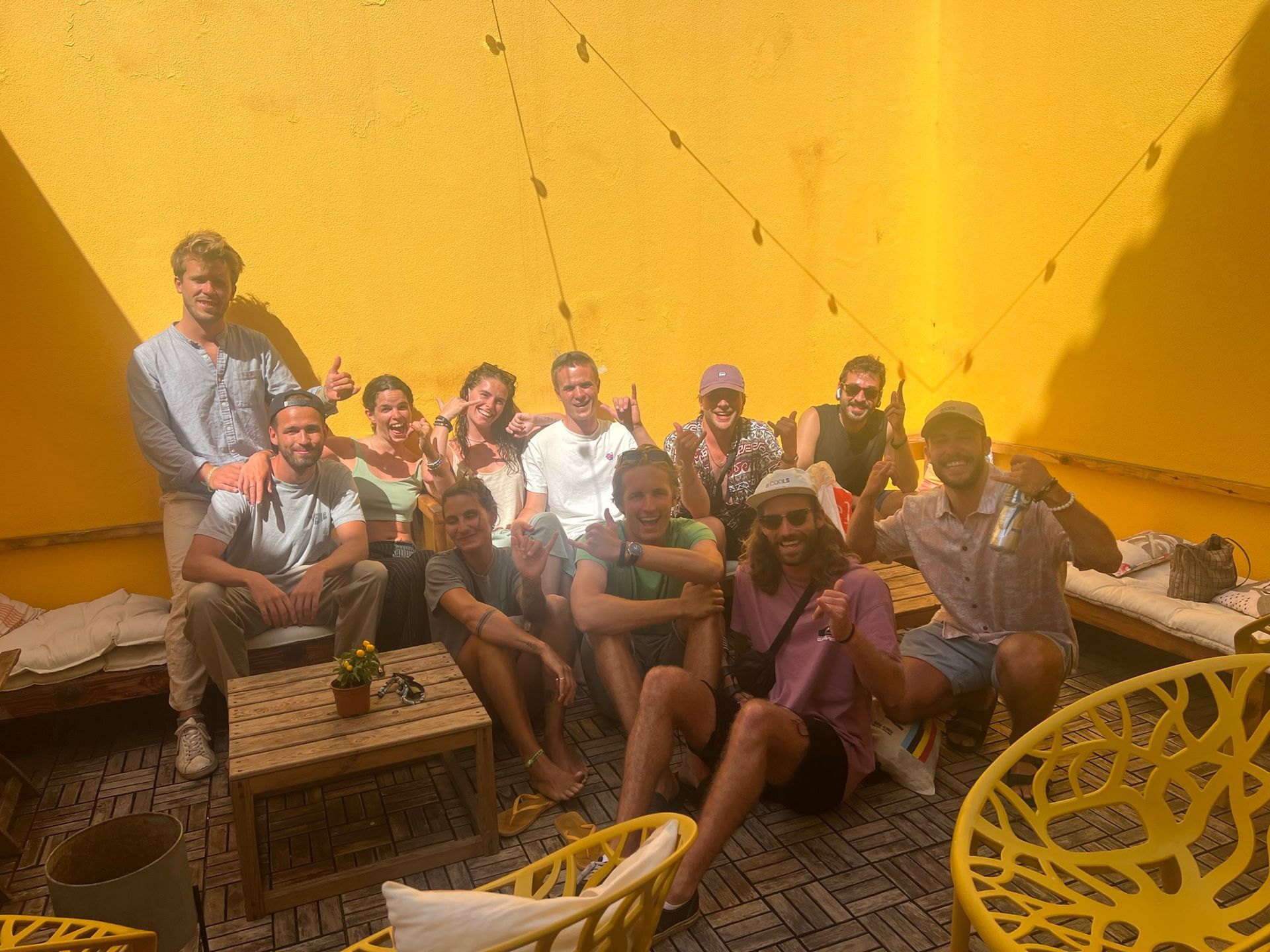 A group of people are posing for a picture in front of a yellow wall.
