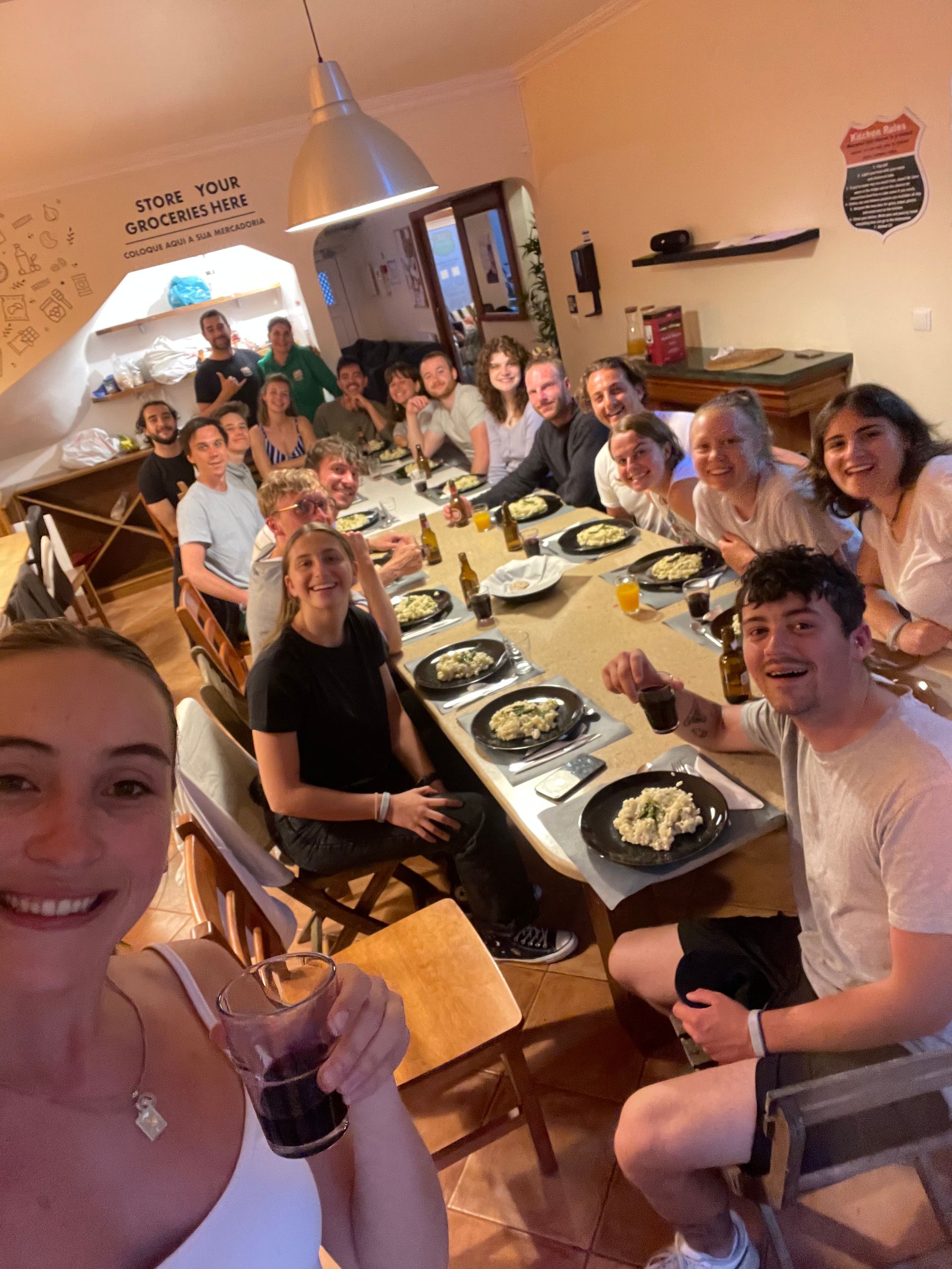 A group of people are sitting around a long table with plates of food.