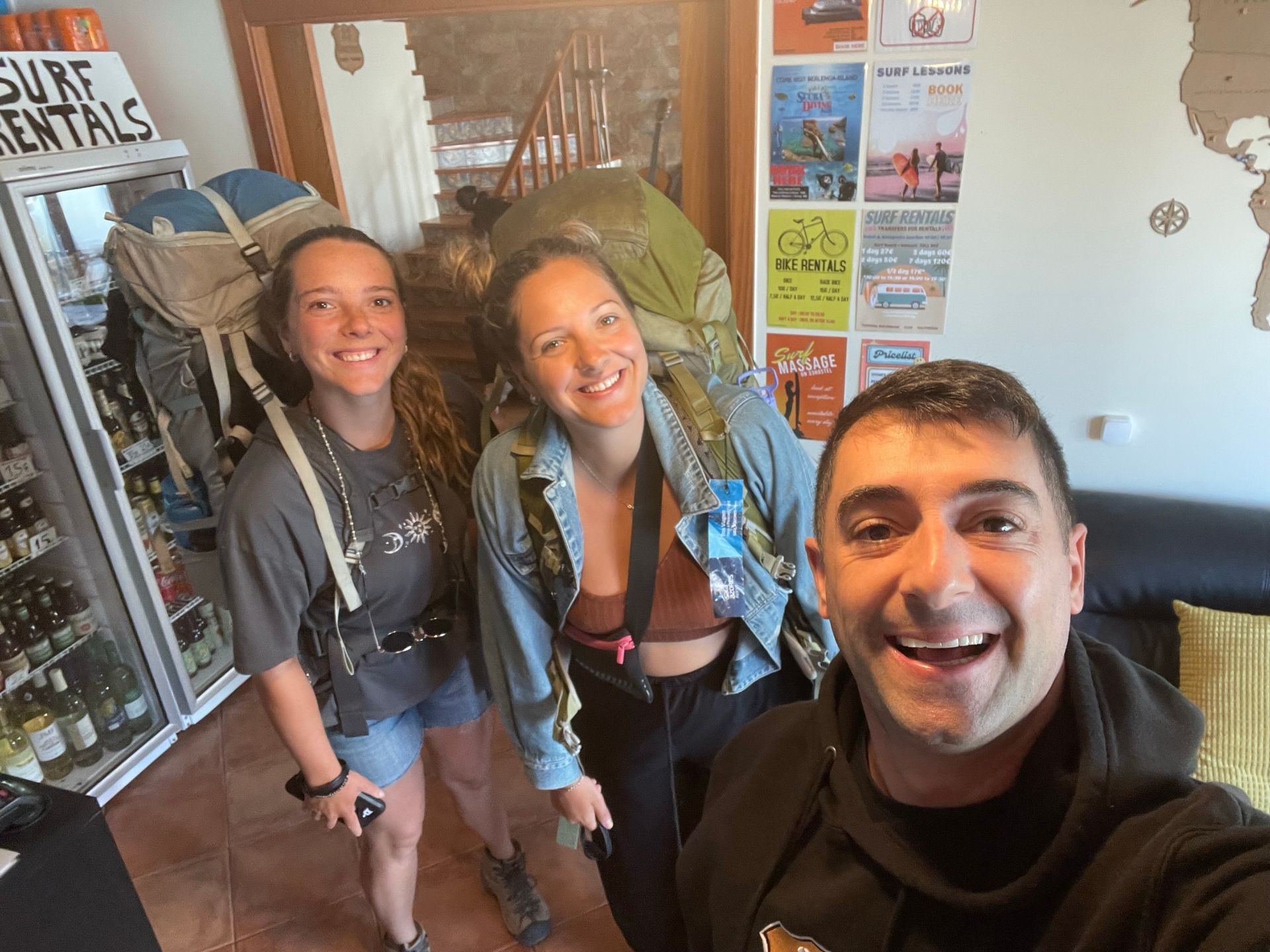 A man and two women are posing for a selfie in a room.