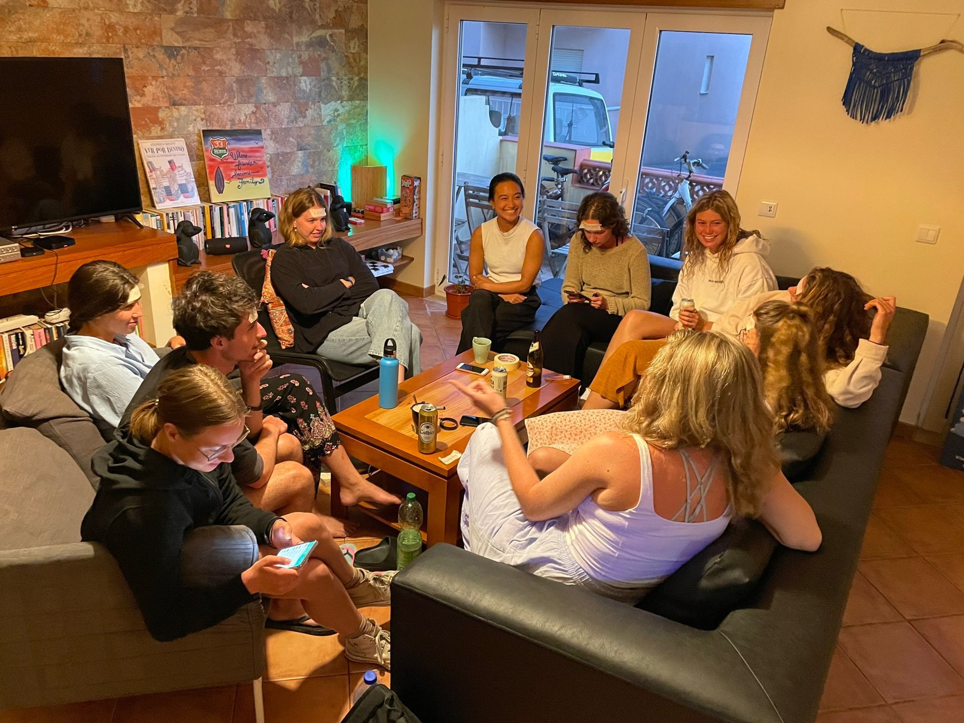 A group of people are sitting around a table in a living room.