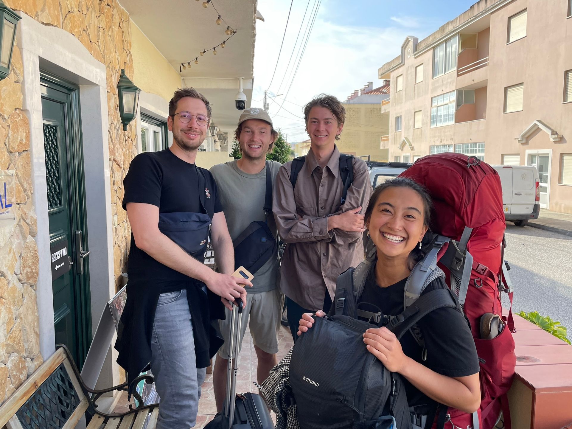 A group of people with backpacks are standing in front of a building.