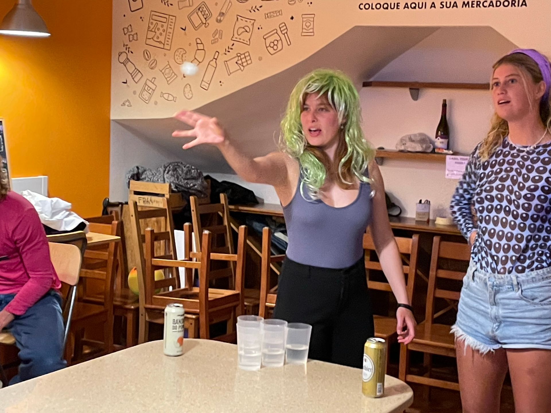 A woman in a green wig is standing in a restaurant
