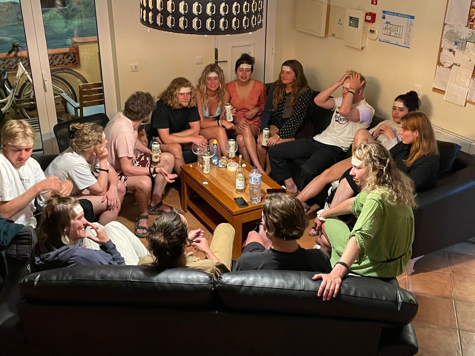 A group of people are sitting around a table in a living room.