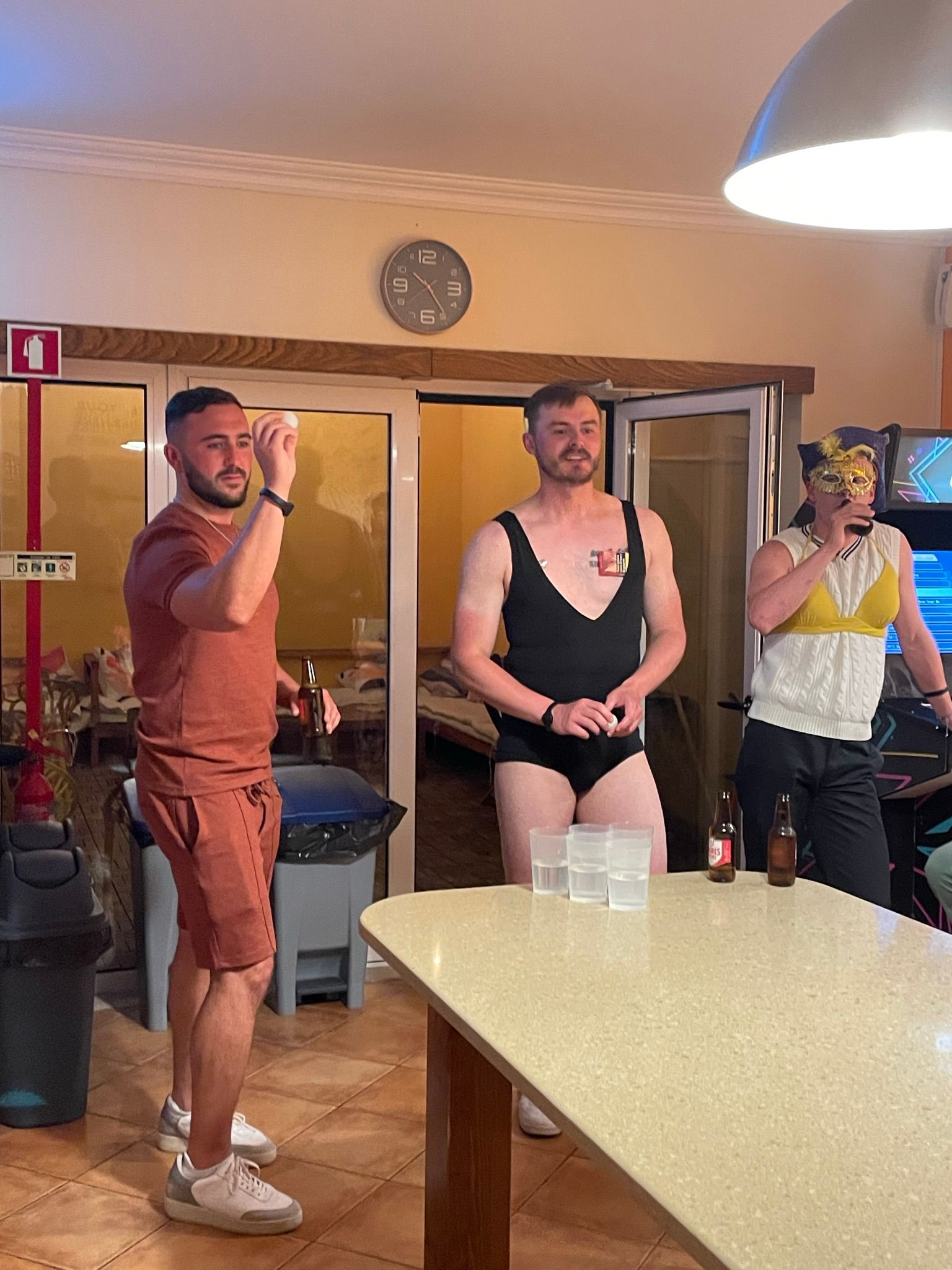 A group of men are standing around a table in a room.