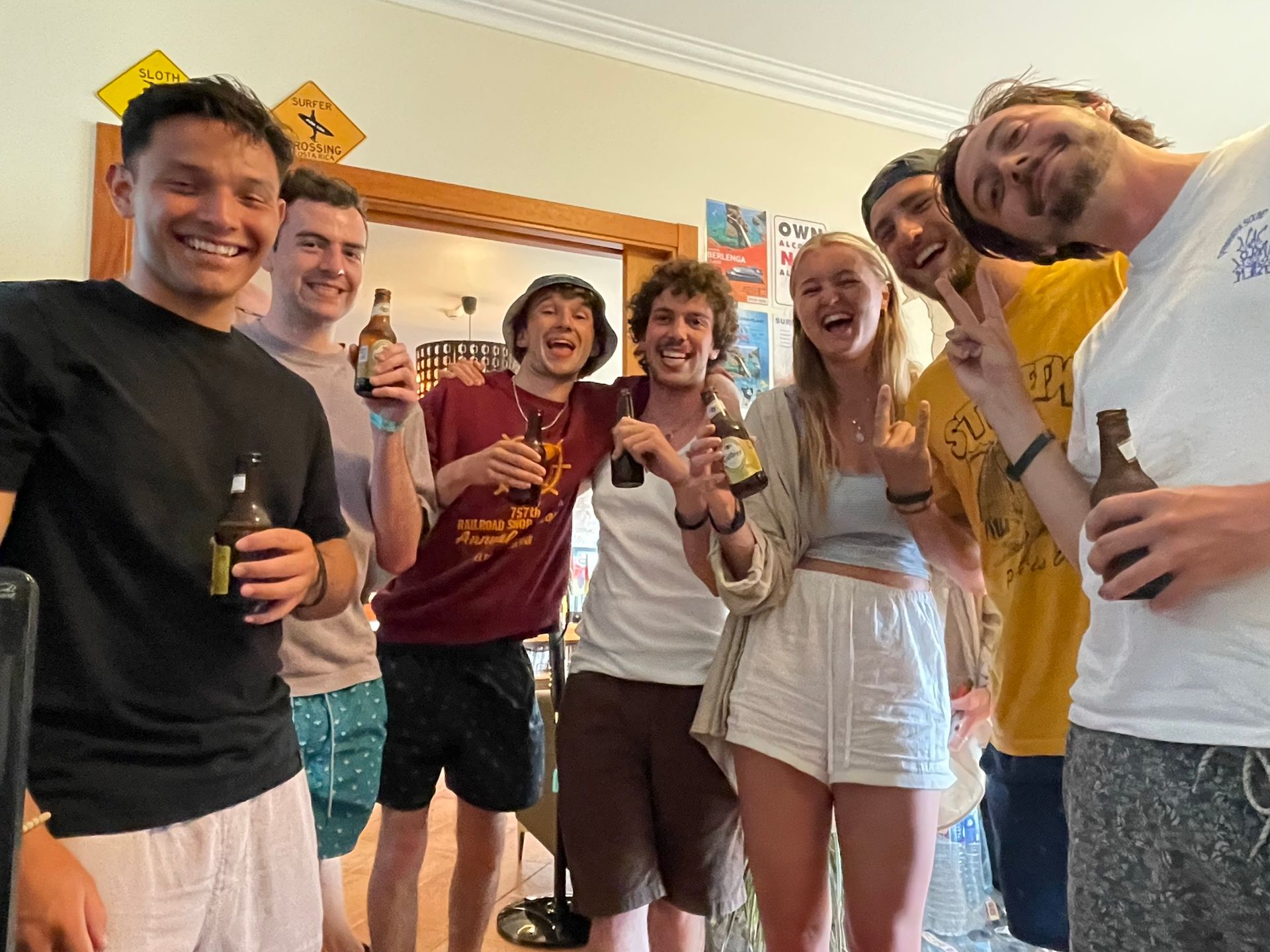 A group of people are posing for a picture while holding bottles of beer.