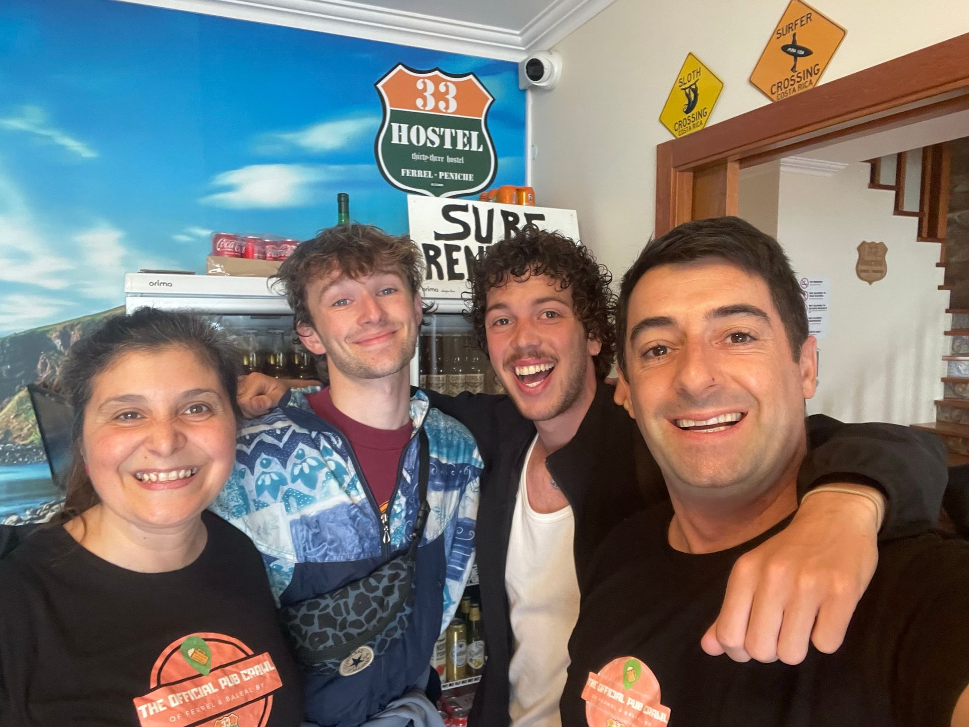 A group of people are posing for a picture in front of a sign that says hostel 33