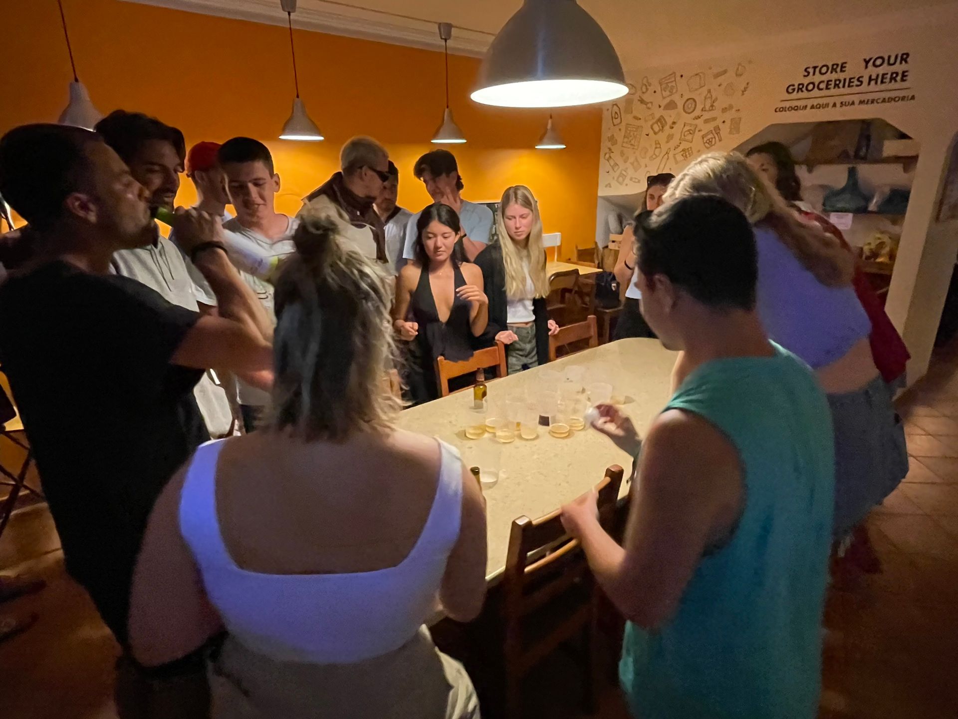 A group of people are standing around a table in a room with a sign on the wall that says new your connections