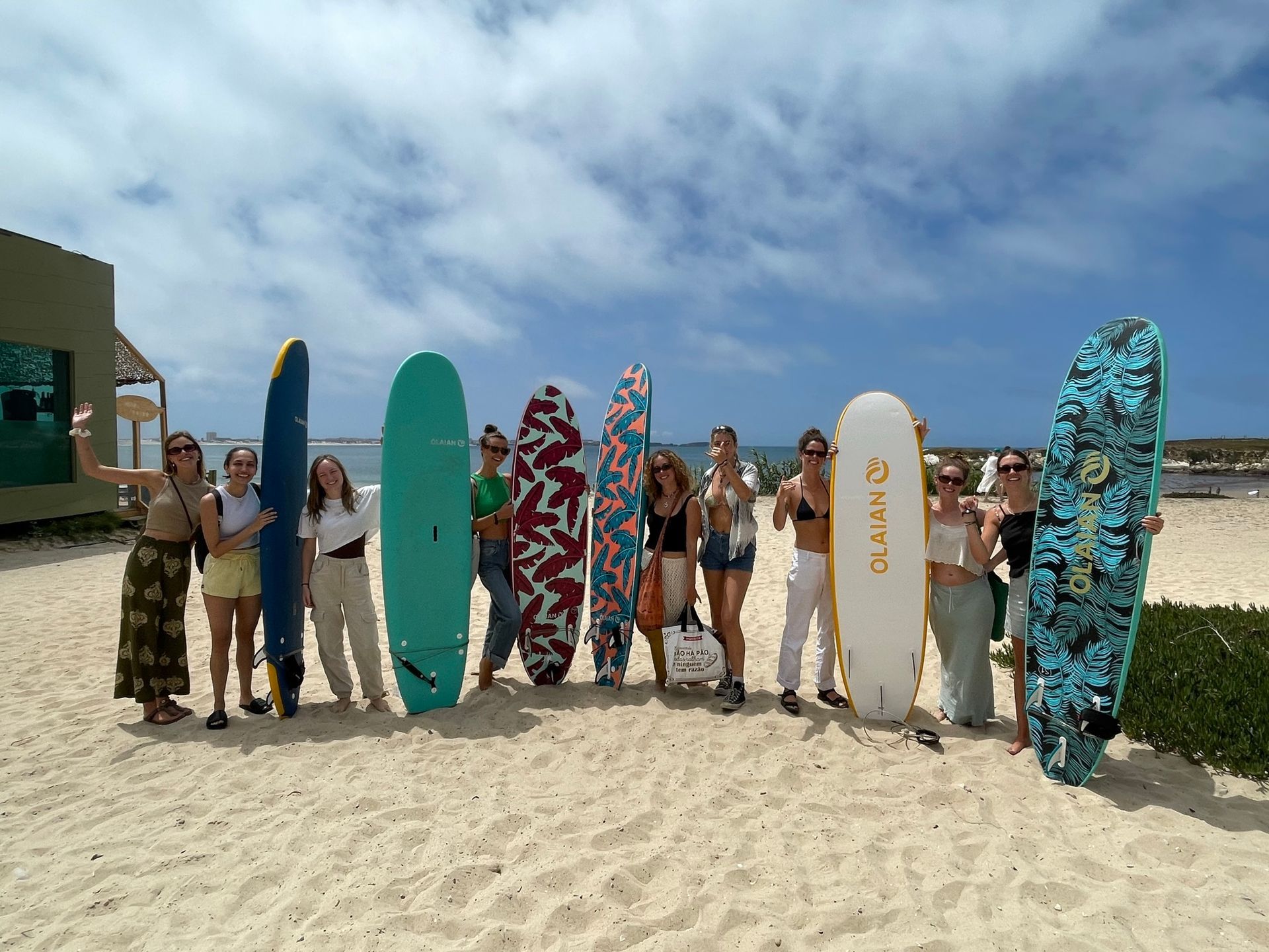 A group of people holding surfboards on a beach