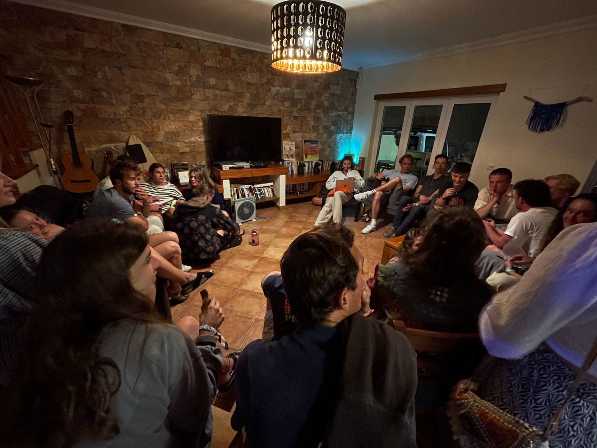 A group of people are sitting in a circle in a living room.
