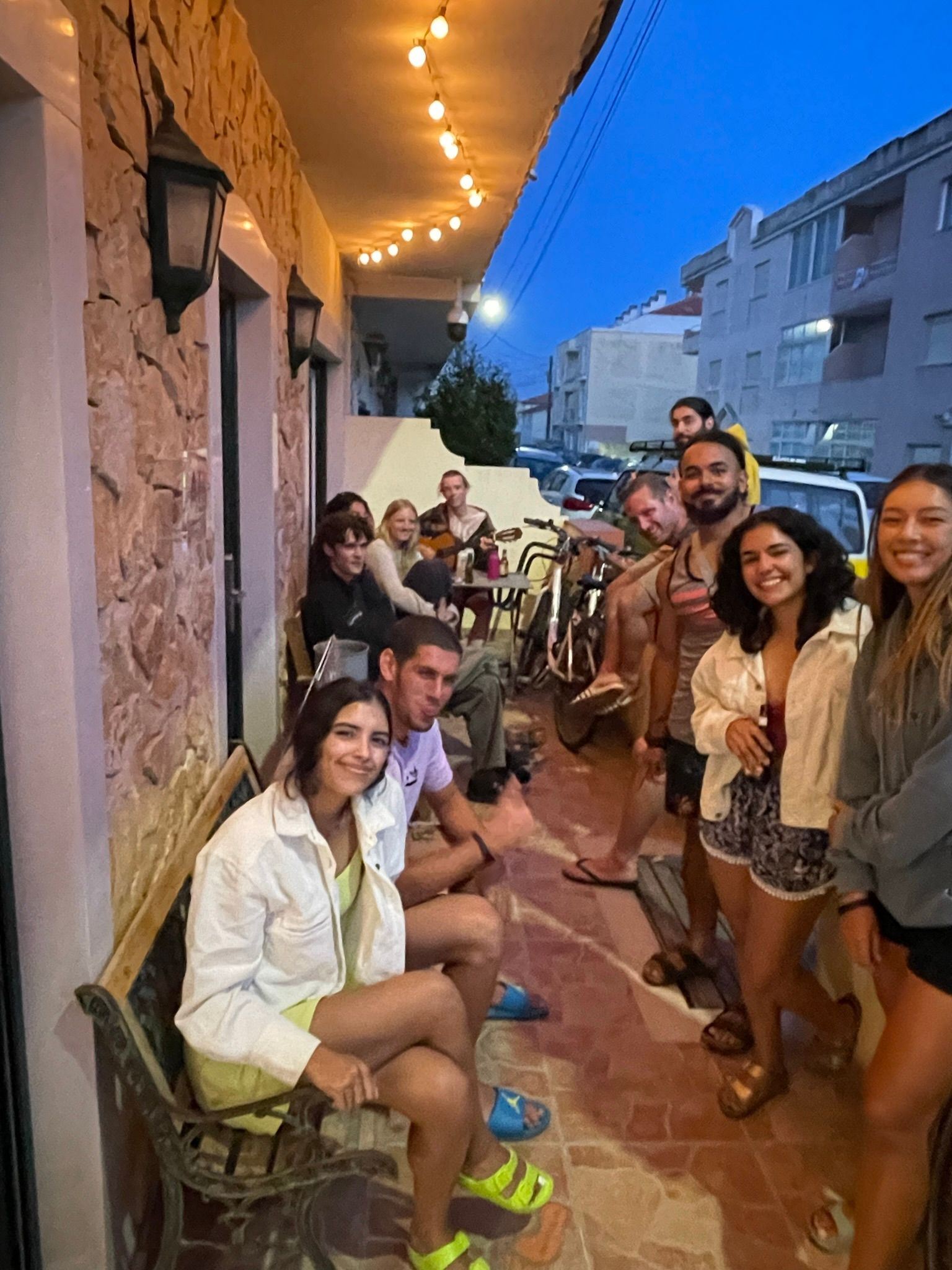 A group of people are sitting on a bench on a balcony.