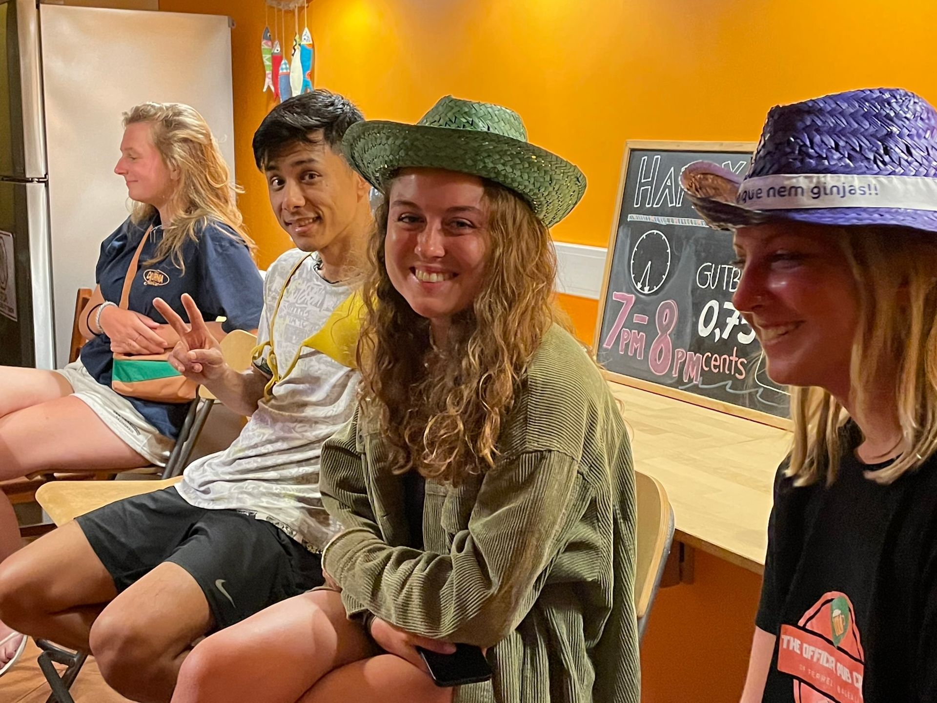 A group of people are sitting at a table wearing hats.