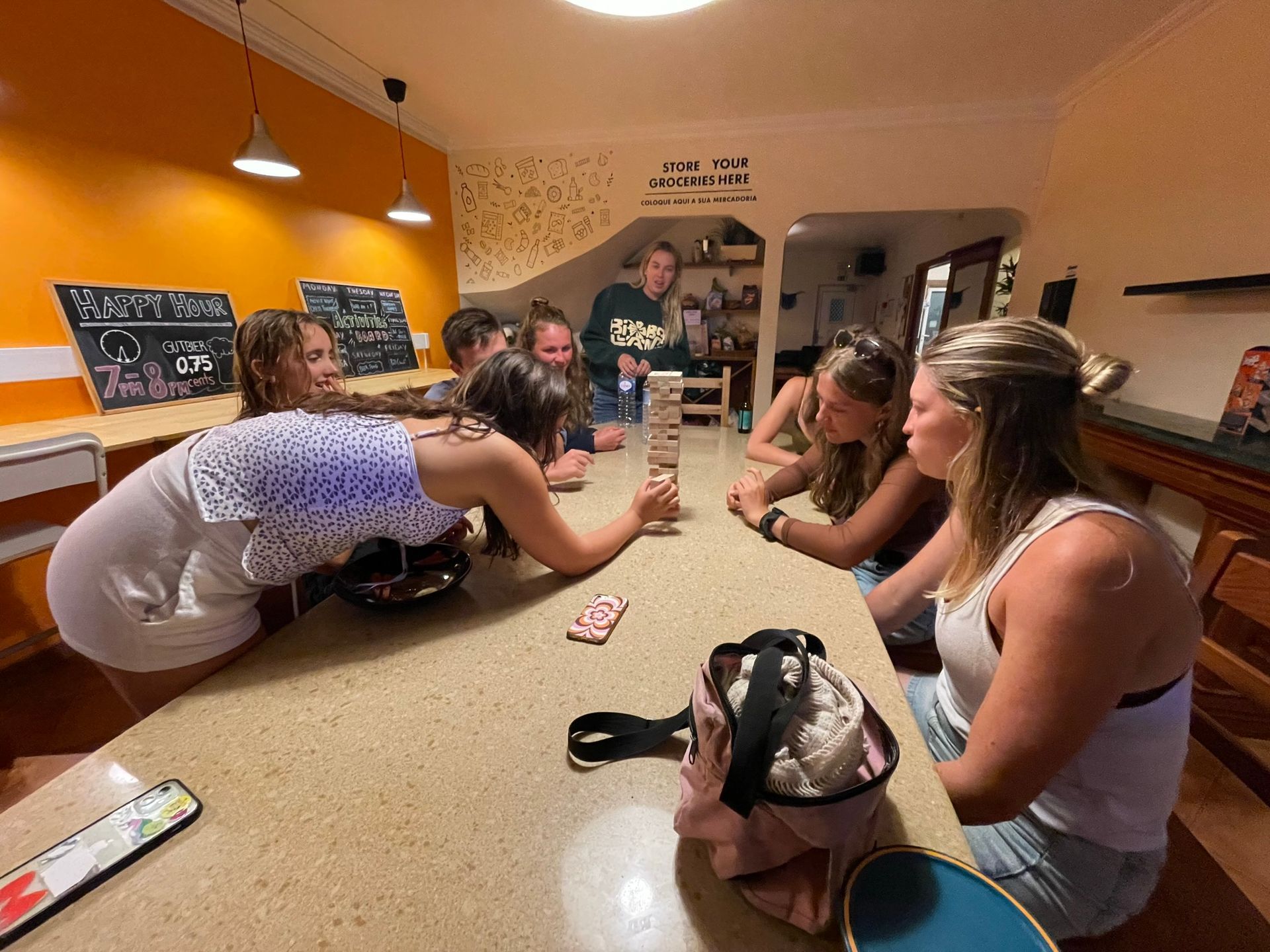 A group of people are sitting around a table playing jenga.
