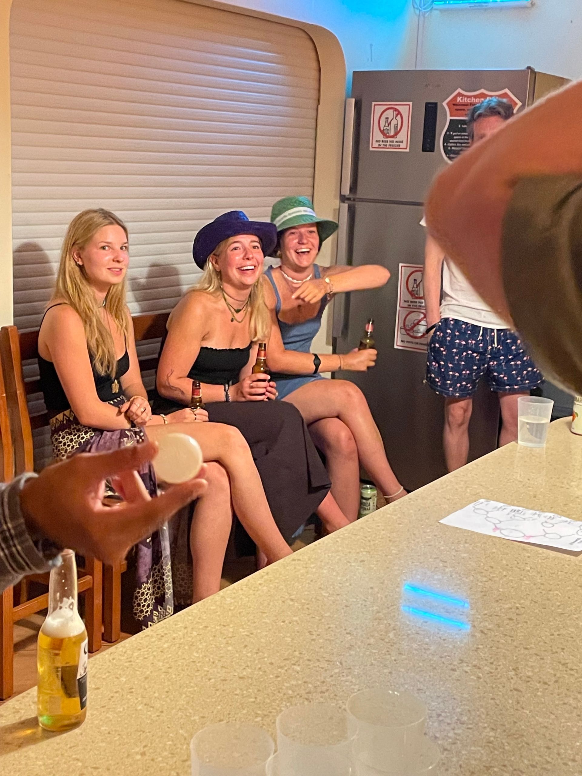 A group of people are sitting at a table drinking beer.