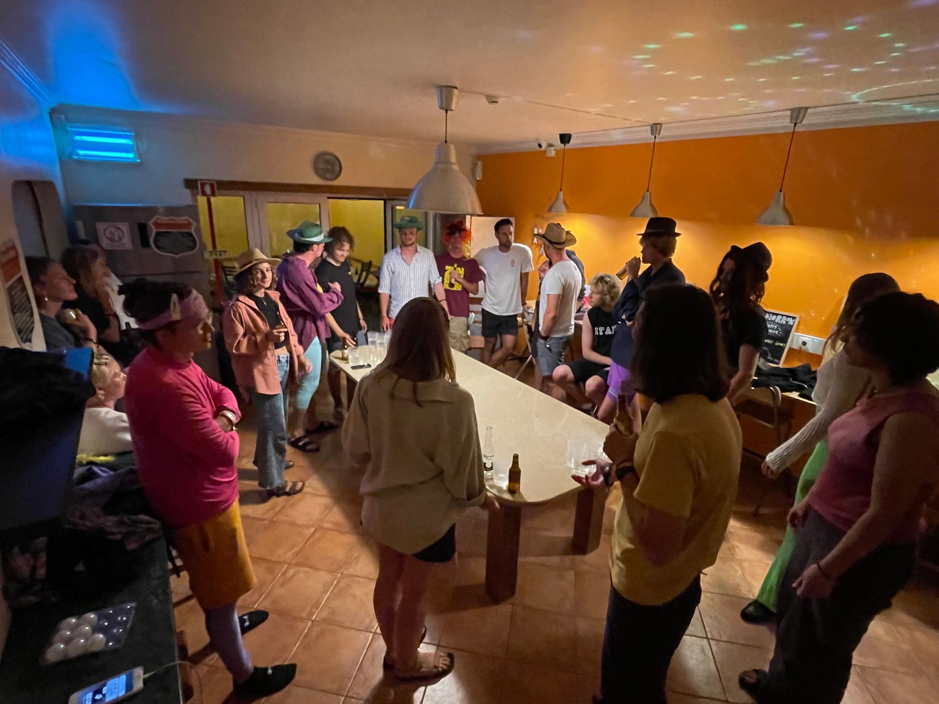 A group of people are standing around a long table in a room.