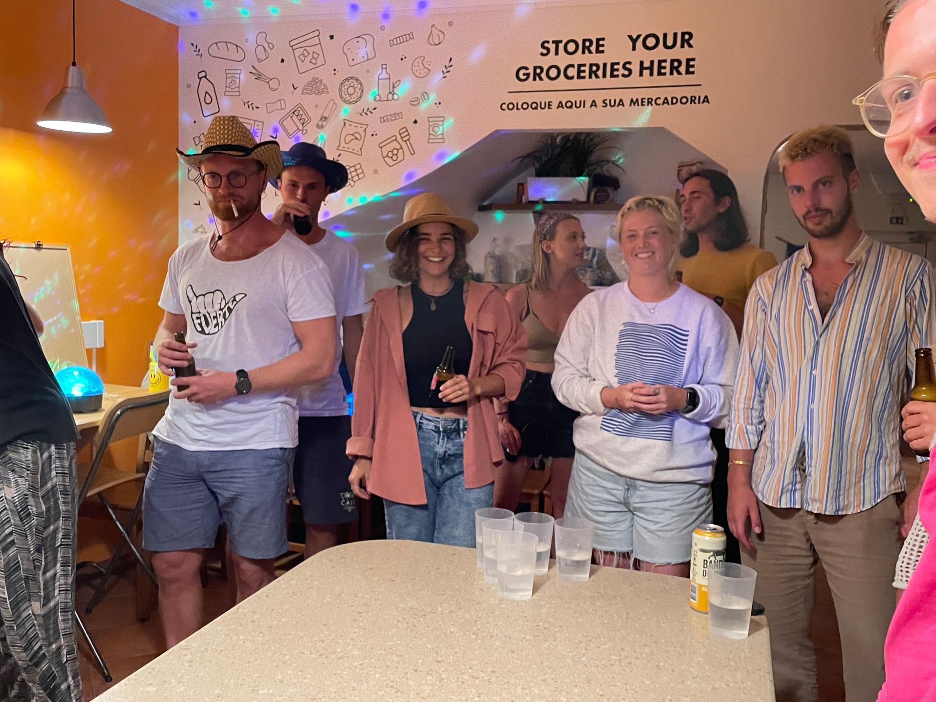 A group of people are standing around a table holding drinks.