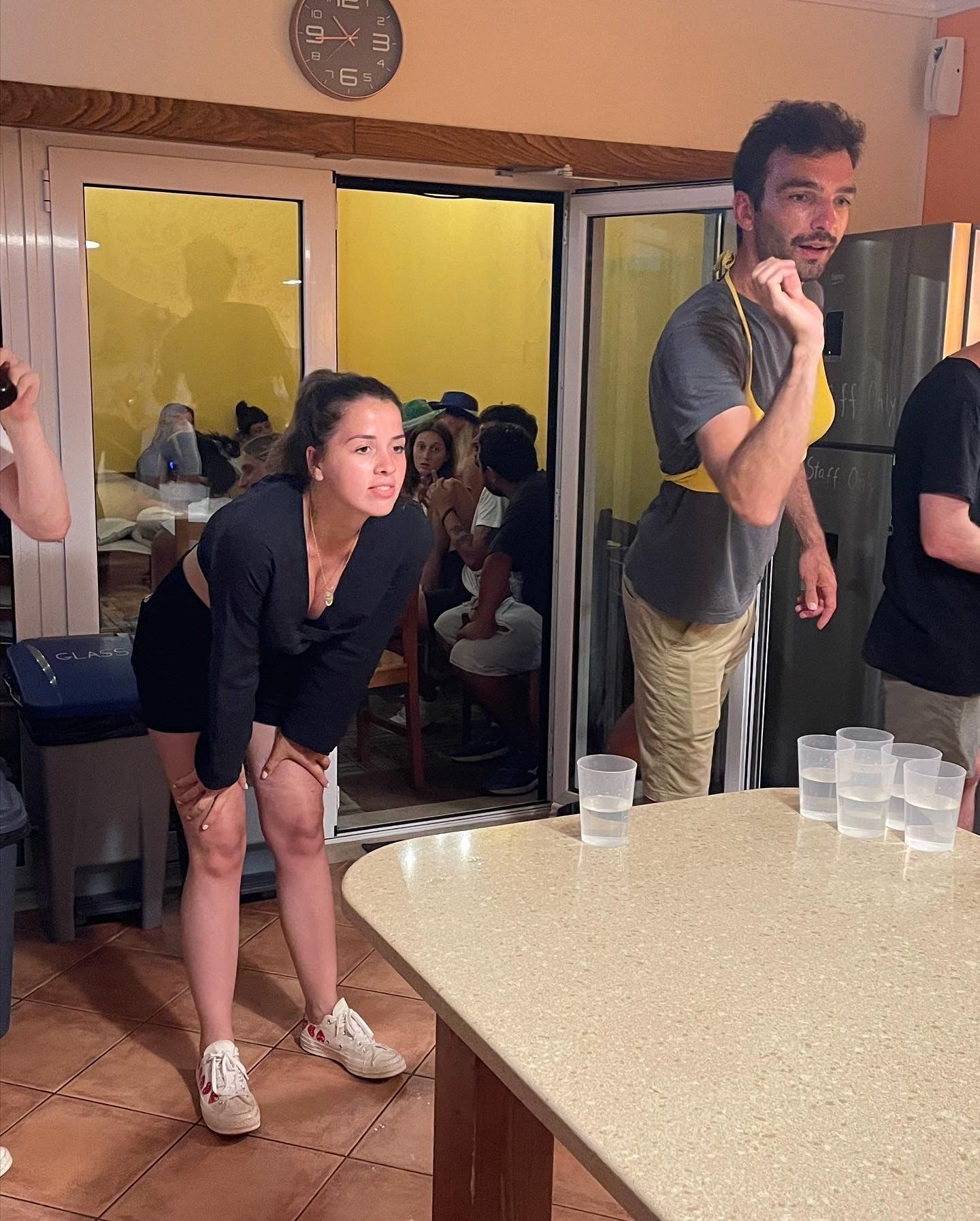 A group of people standing around a table with glasses on it
