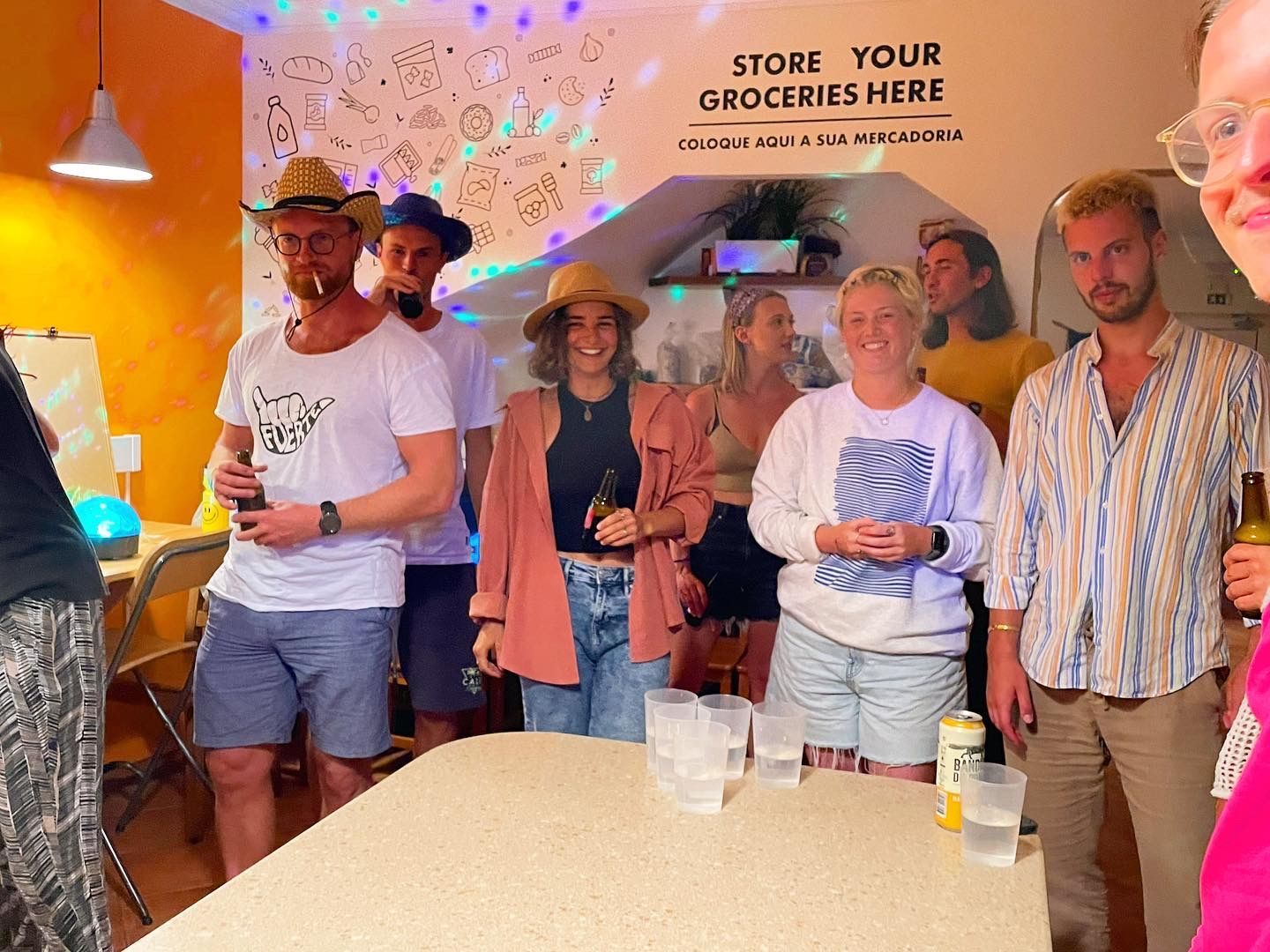 A group of people standing around a table with a sign that says store your groceries here.