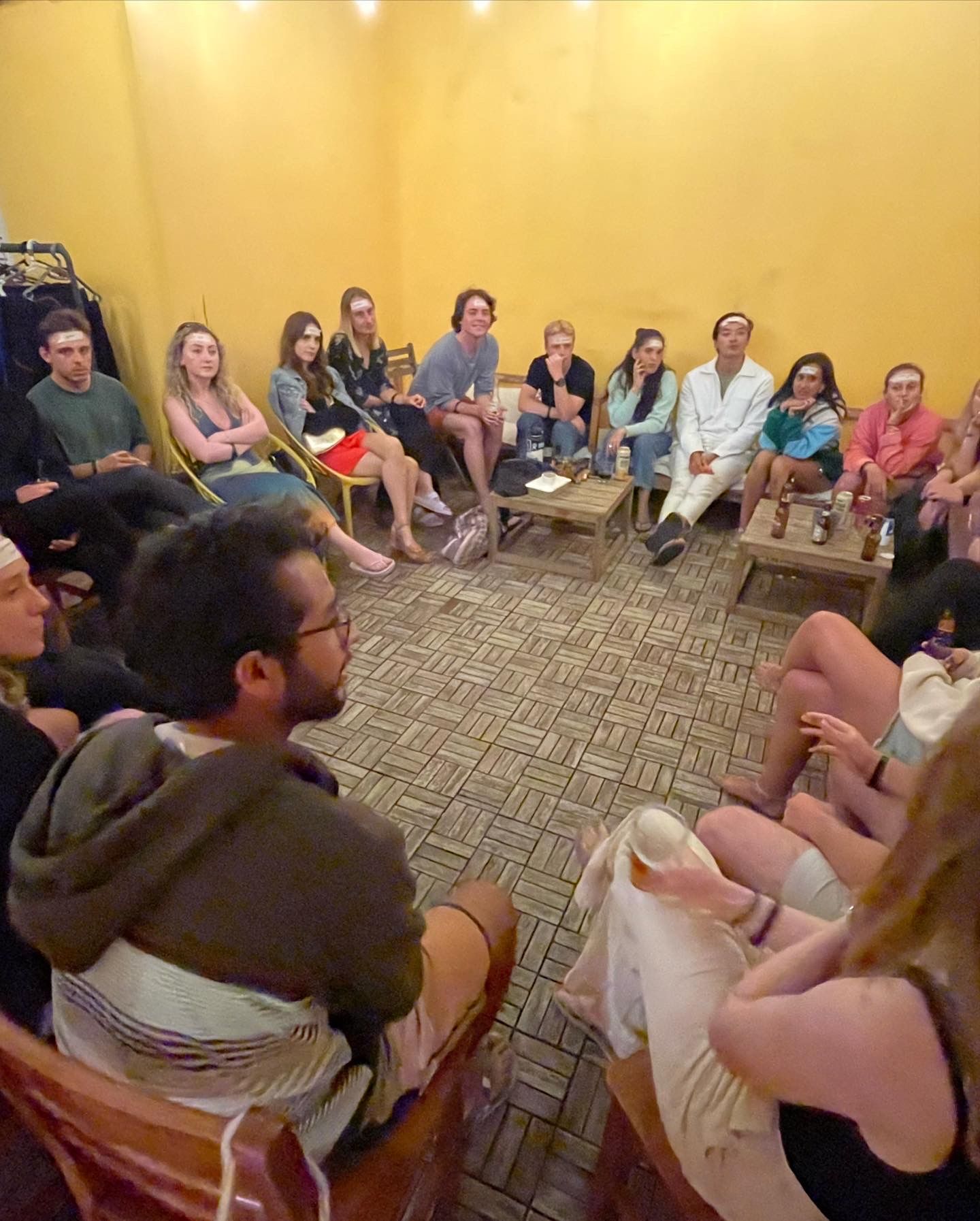 A group of people are sitting in a circle in a room.