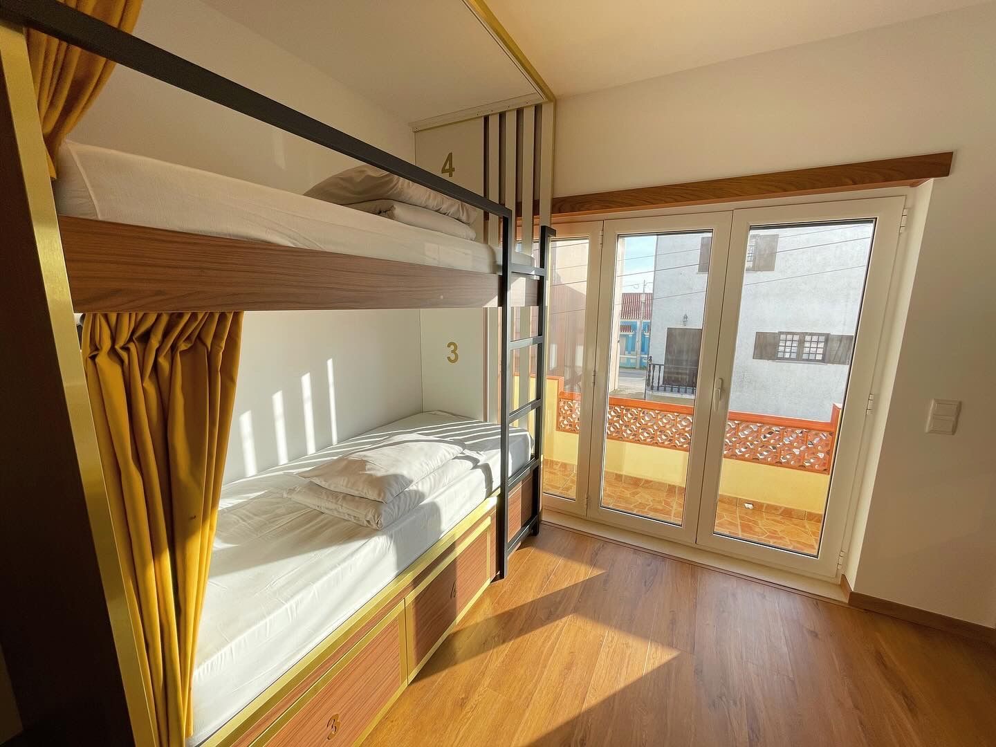 A bunk bed in a room with a large window.