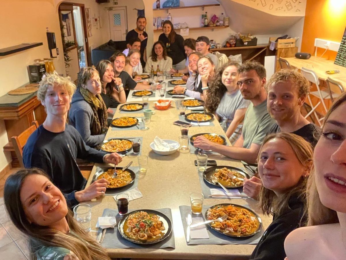 A group of people are sitting at a long table with plates of food.