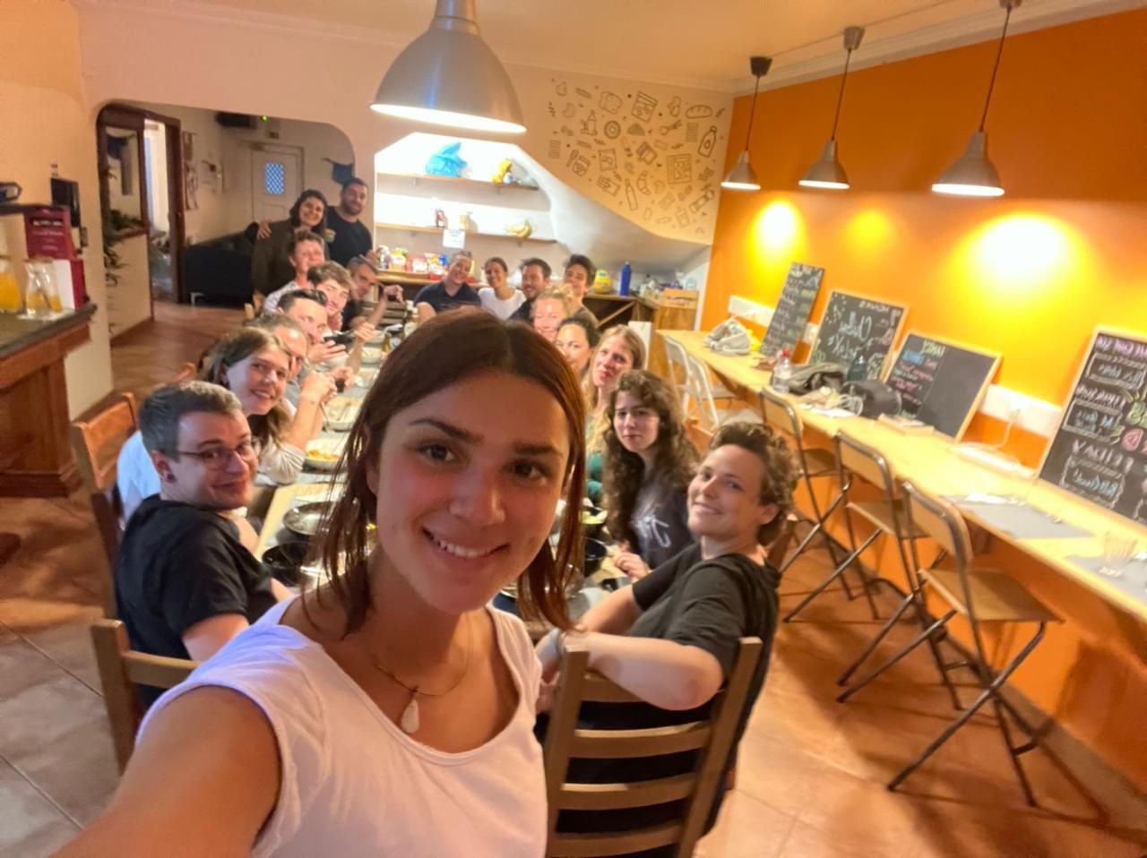A group of people are sitting at a long table in a restaurant.